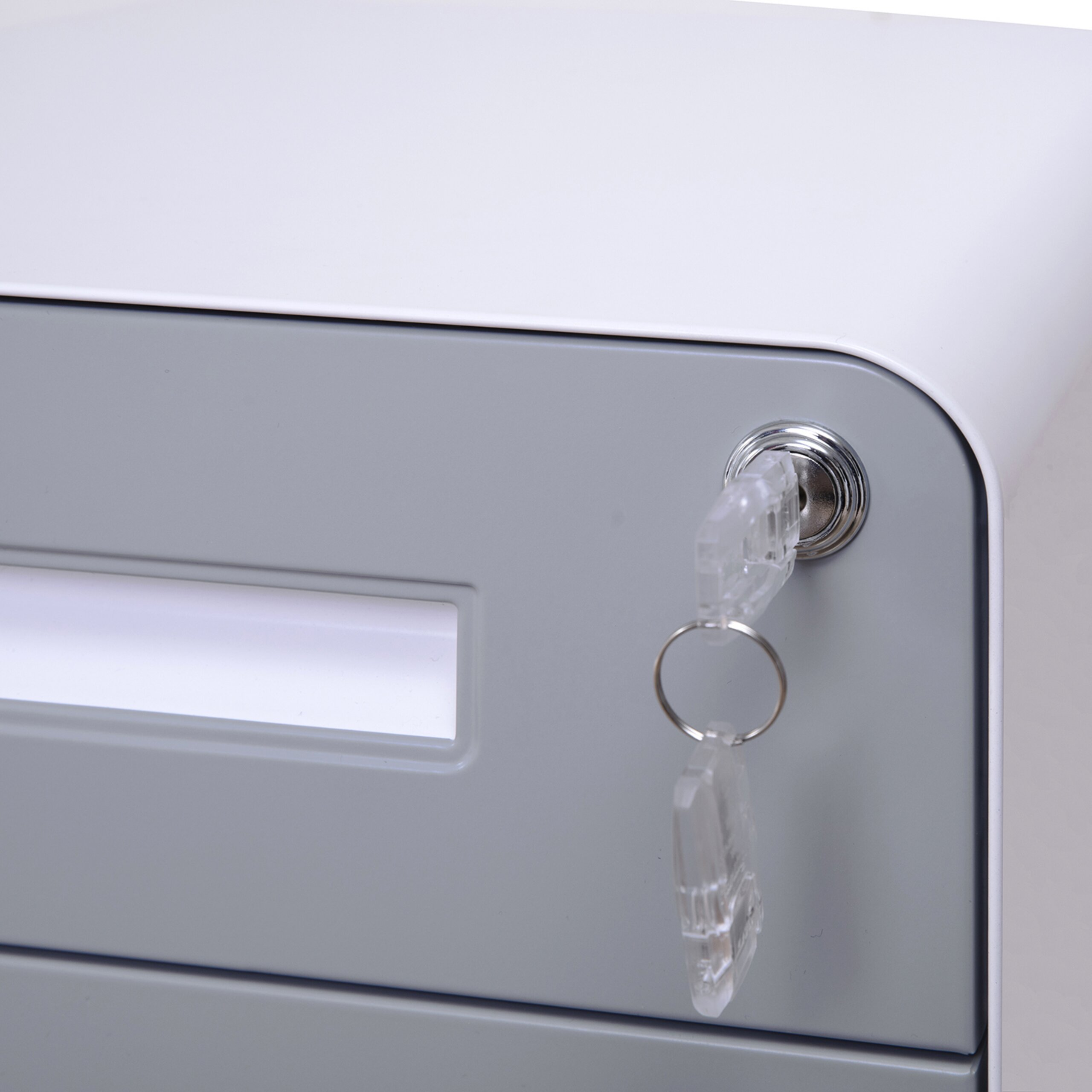 Ein weißer Aktenschrank mit grauen Schubladen und zwei Schlüsseln im Schloss.