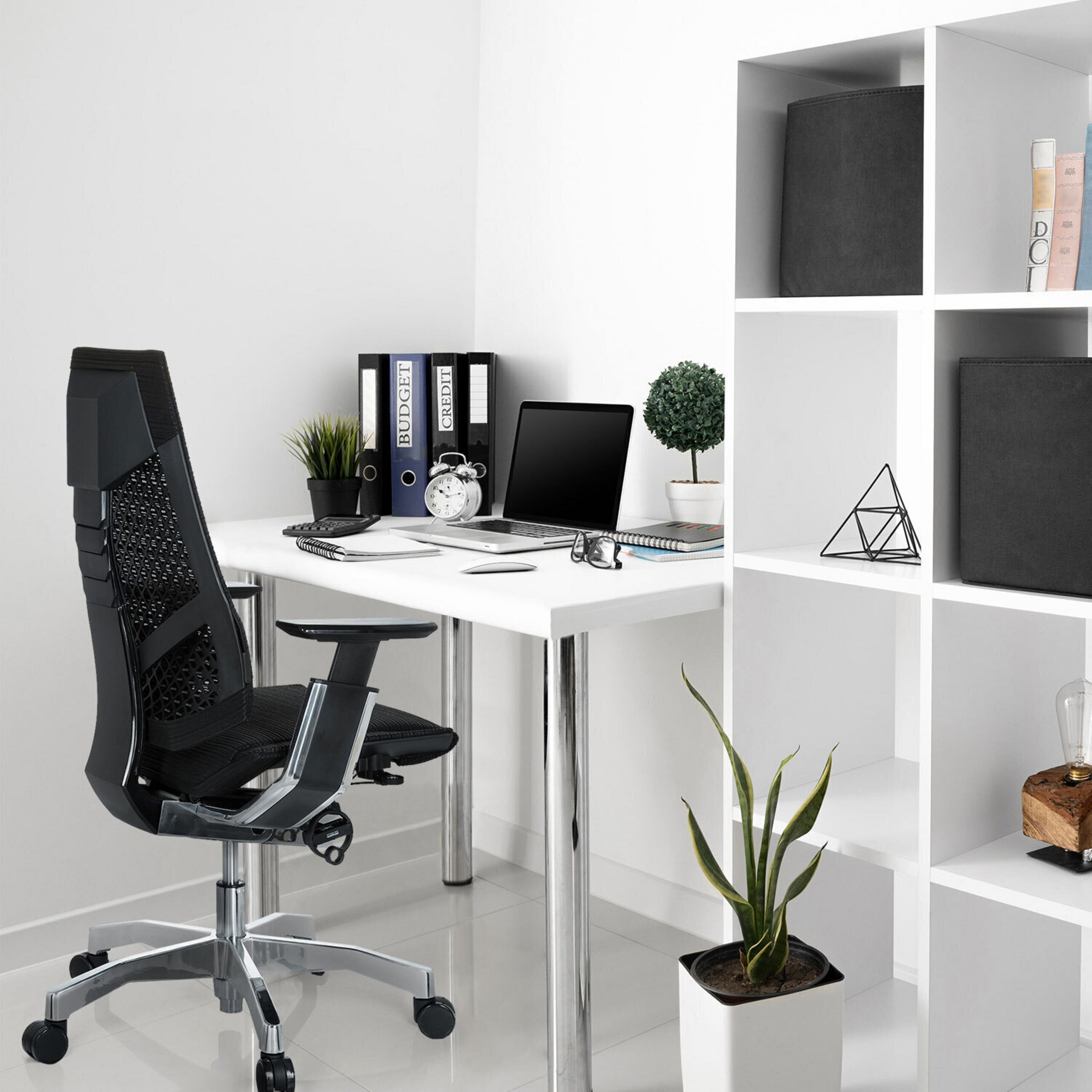 Moderne Büro-Ecke mit weißem Schreibtisch, schwarzem Drehstuhl, Laptop, Aktenordnern und Regalen in einem hellen Zimmer.