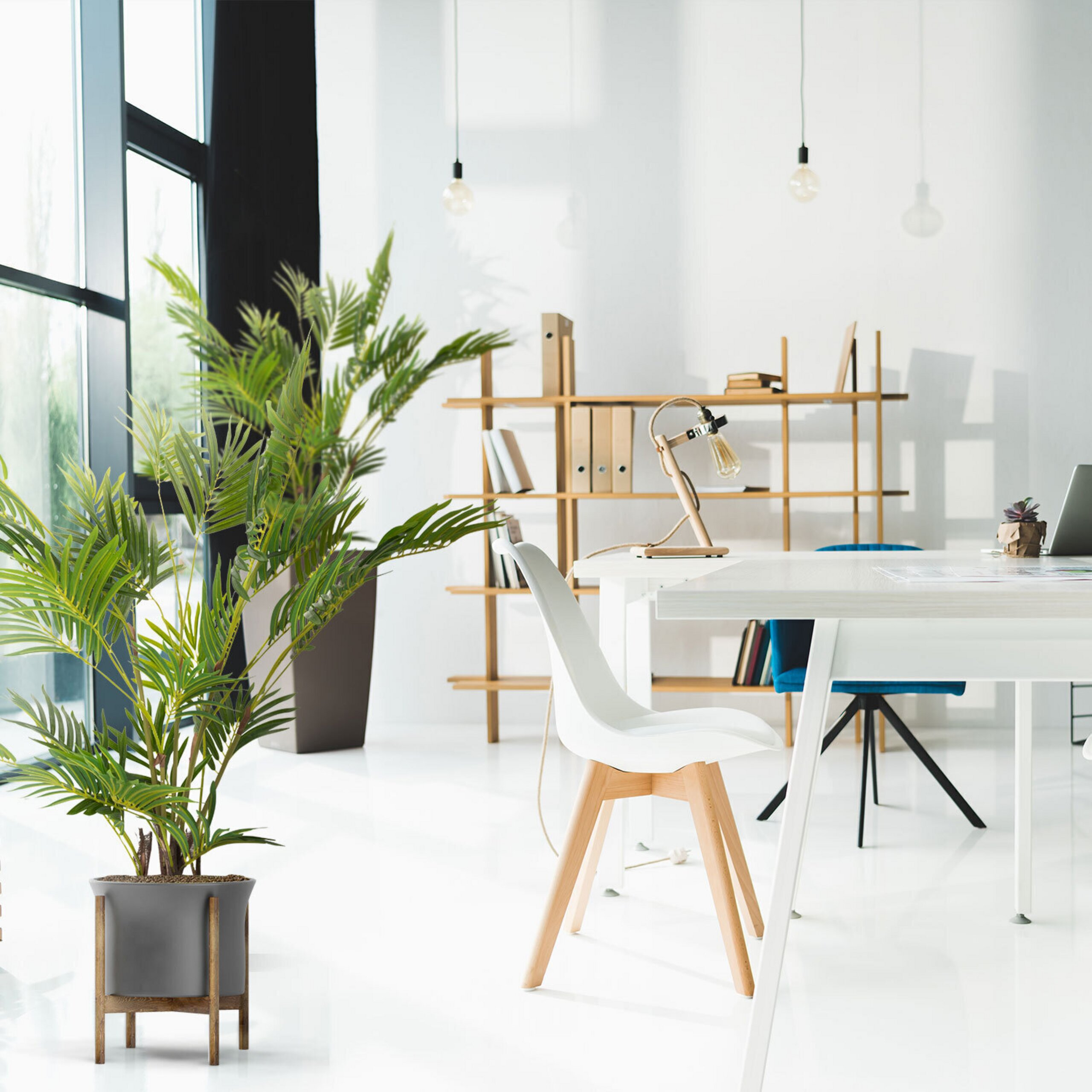 Helles modernes Büro mit weißen Möbeln, Holzbett, großen Fenstern und Zimmerpflanzen.