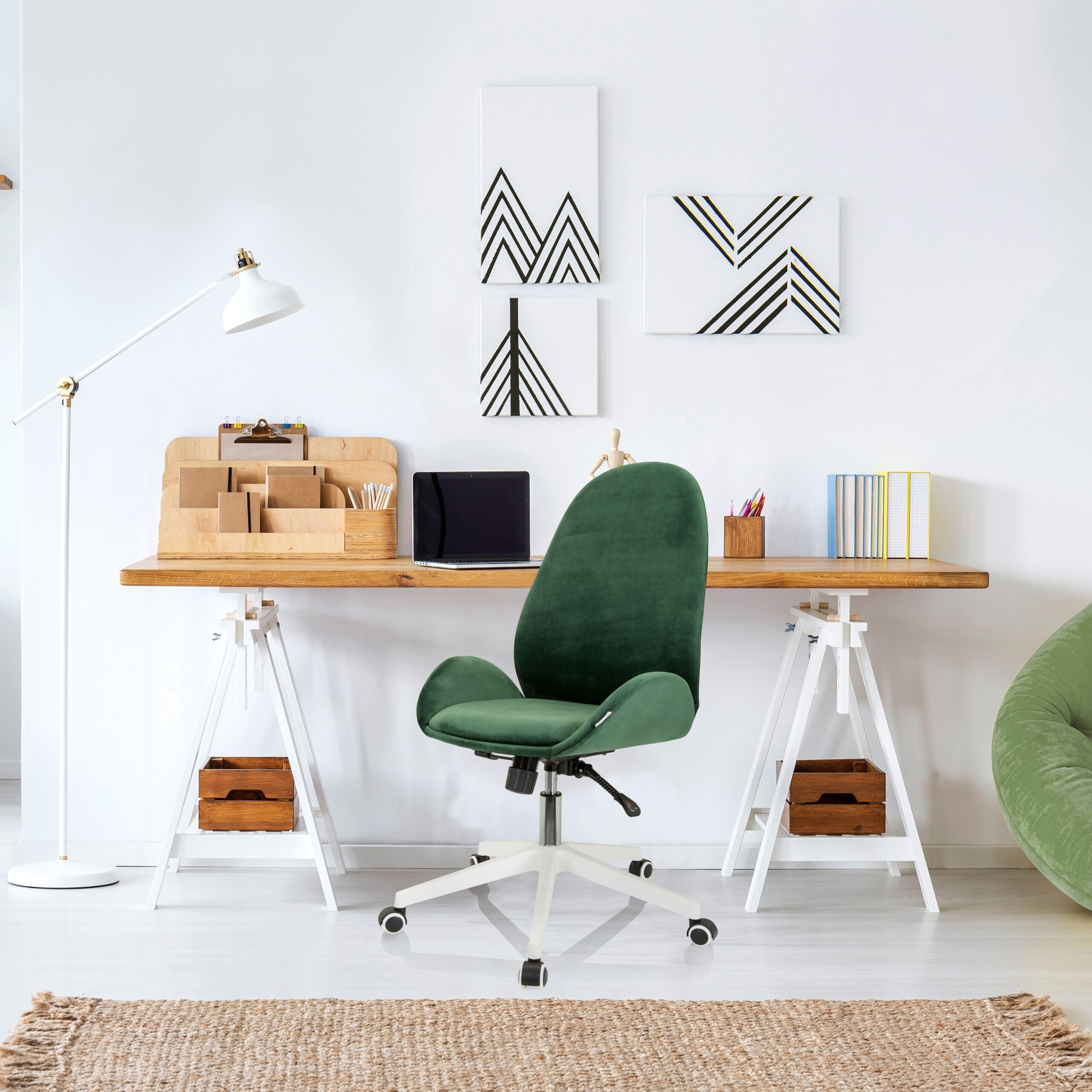 Moderne Schreibtisch mit Holzplatte, grünem Samtstuhl und geometrischer Kunst an weißer Wand.
