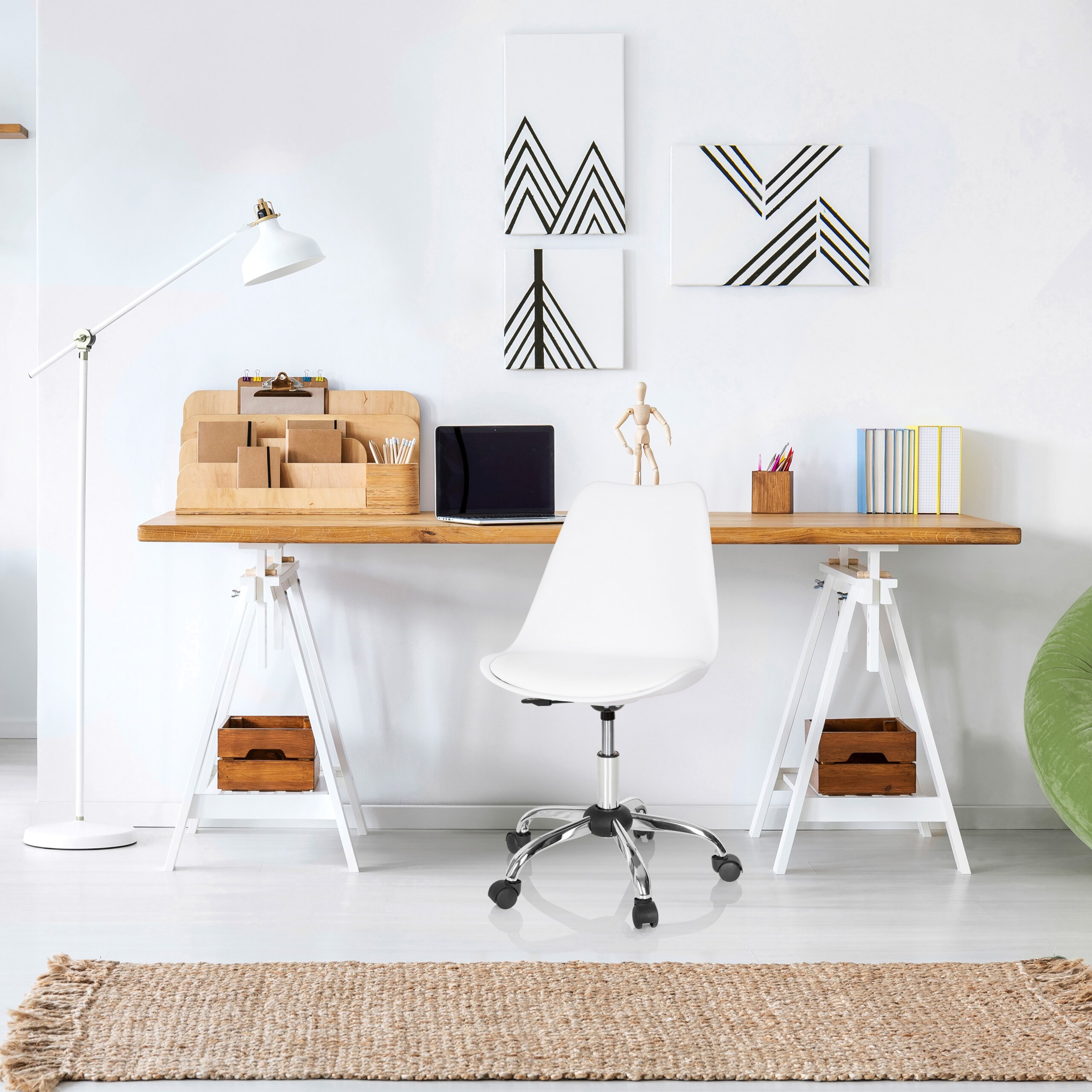 Moderner Arbeitsplatz mit Holztisch, weißem Stuhl, Laptop und abstrakter Wandkunst in einem hellen Zimmer.