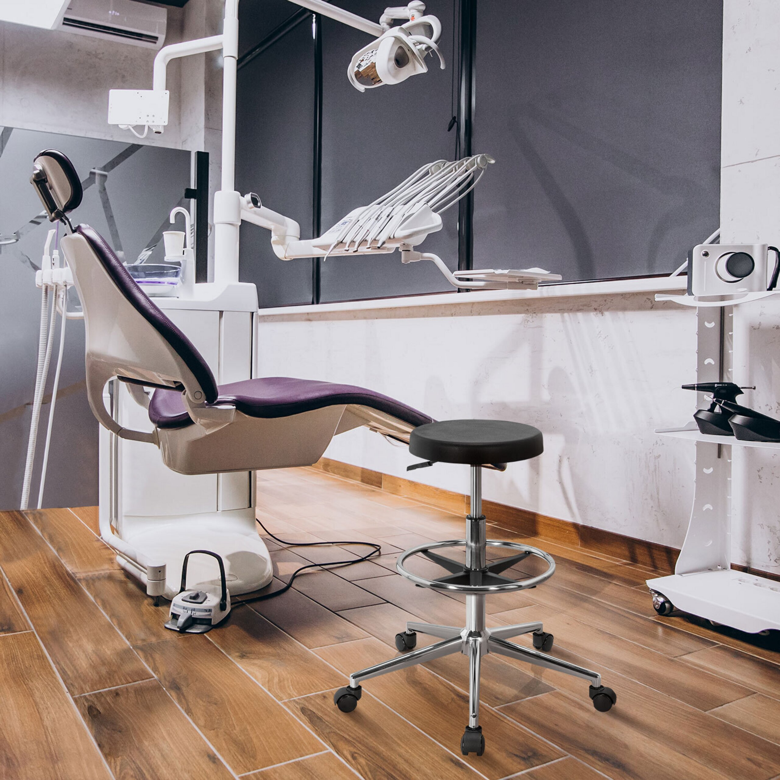 Eine moderne Zahnarztpraxis mit violettem Patientenstuhl, medizinischen Geräten und Rollhocker auf Holzboden.