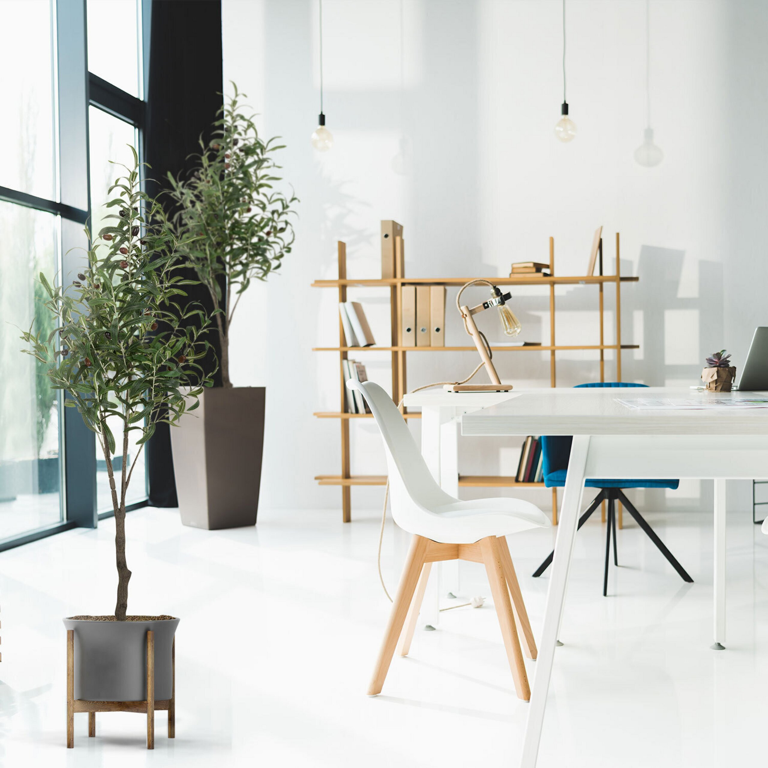 Helles, modernes Büro mit Topfpflanzen, weißem Schreibtisch, weißem Stuhl und Holzregal an einer weißen Wand.