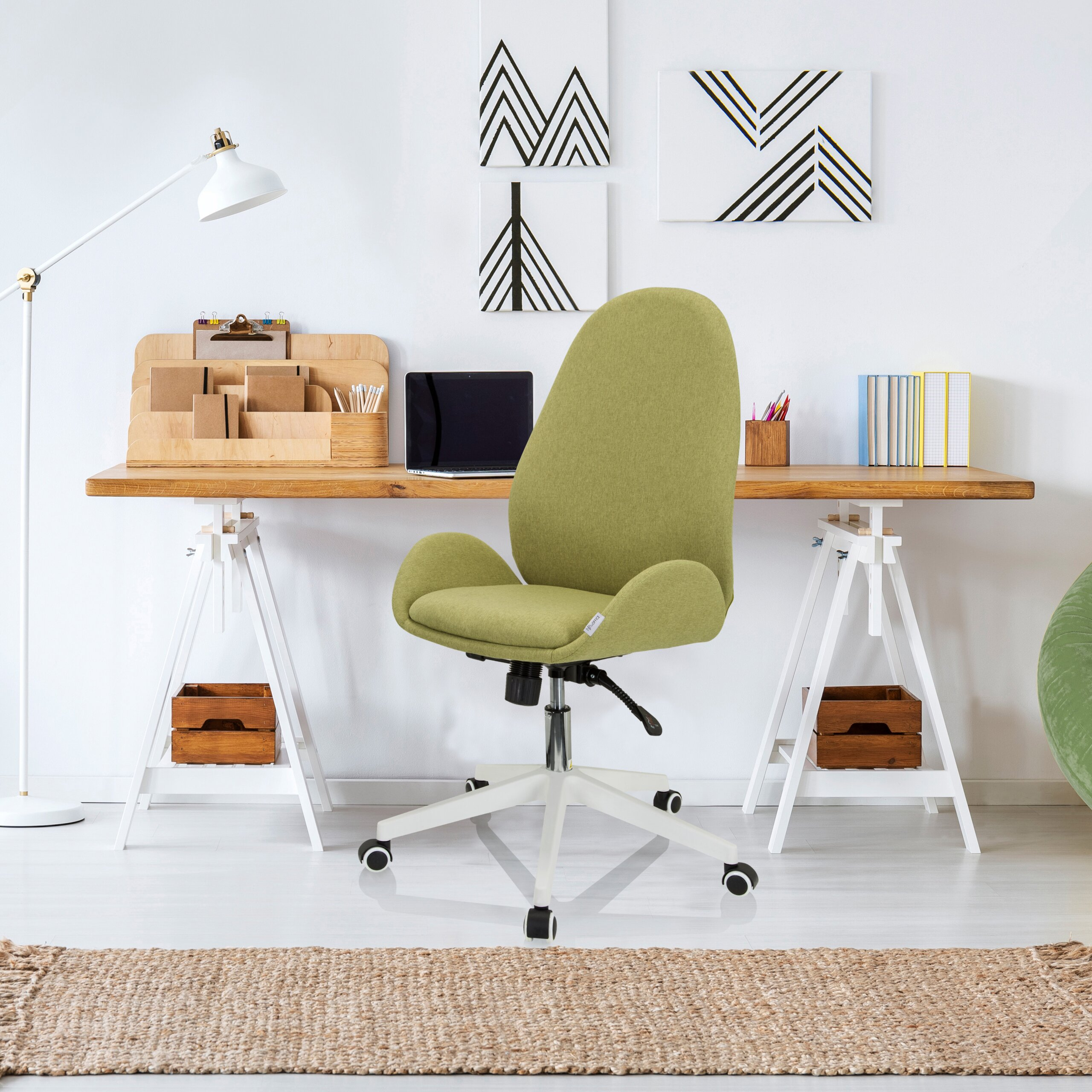Ein grüner Schreibtischstuhl steht in einem modernen Arbeitszimmer vor einem Holztisch.