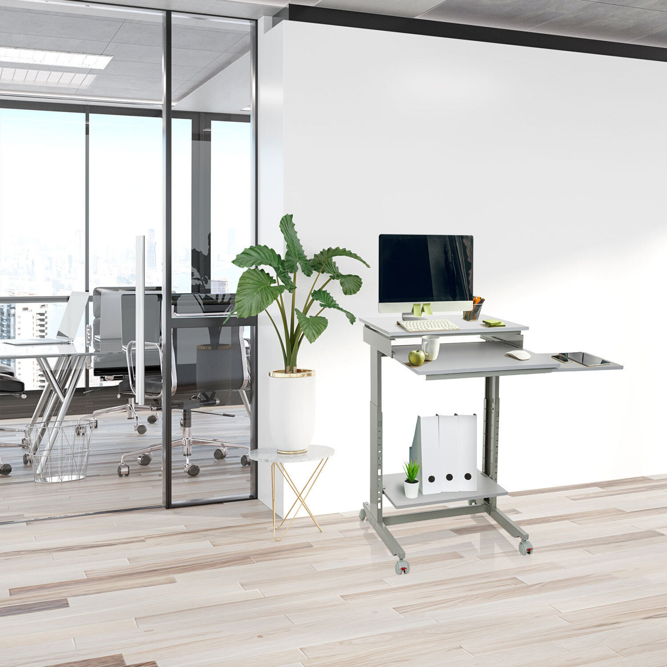 Mobiler Stehschreibtisch mit Computer vor weißer Wand und Glaswand mit Blick auf Stadt.