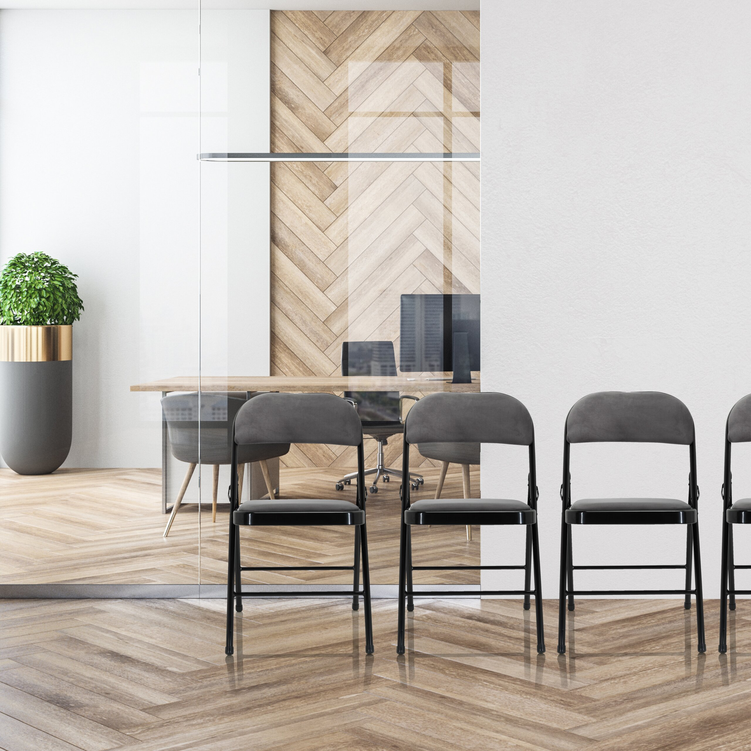 Moderne graue Klappstühle vor einer Glastrennwand in einem holzverkleideten Büro.