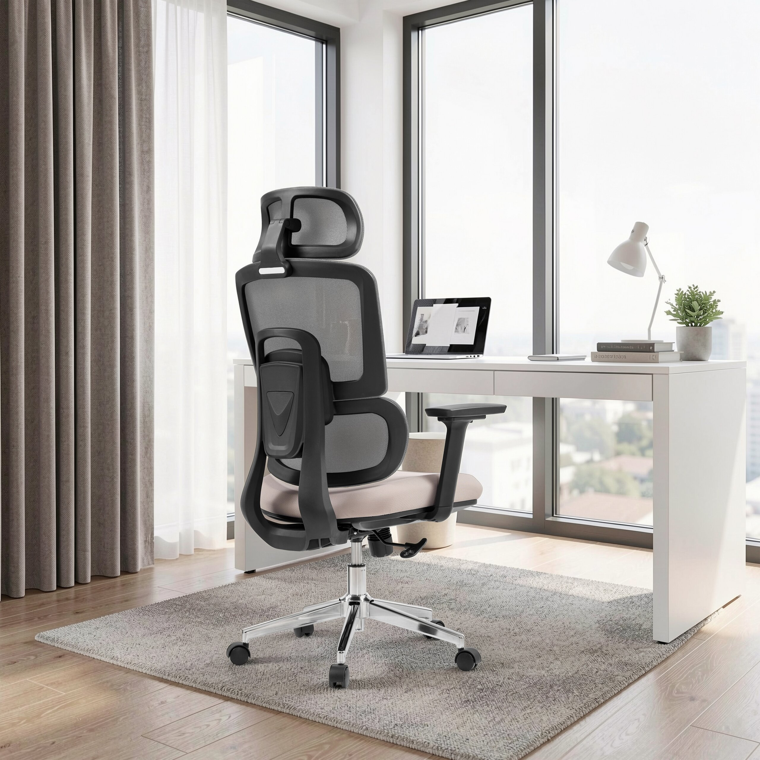 Ergonomischer schwarzer Bürostuhl vor einem weißen Schreibtisch mit Laptop und Lampe vor großen Fenstern.