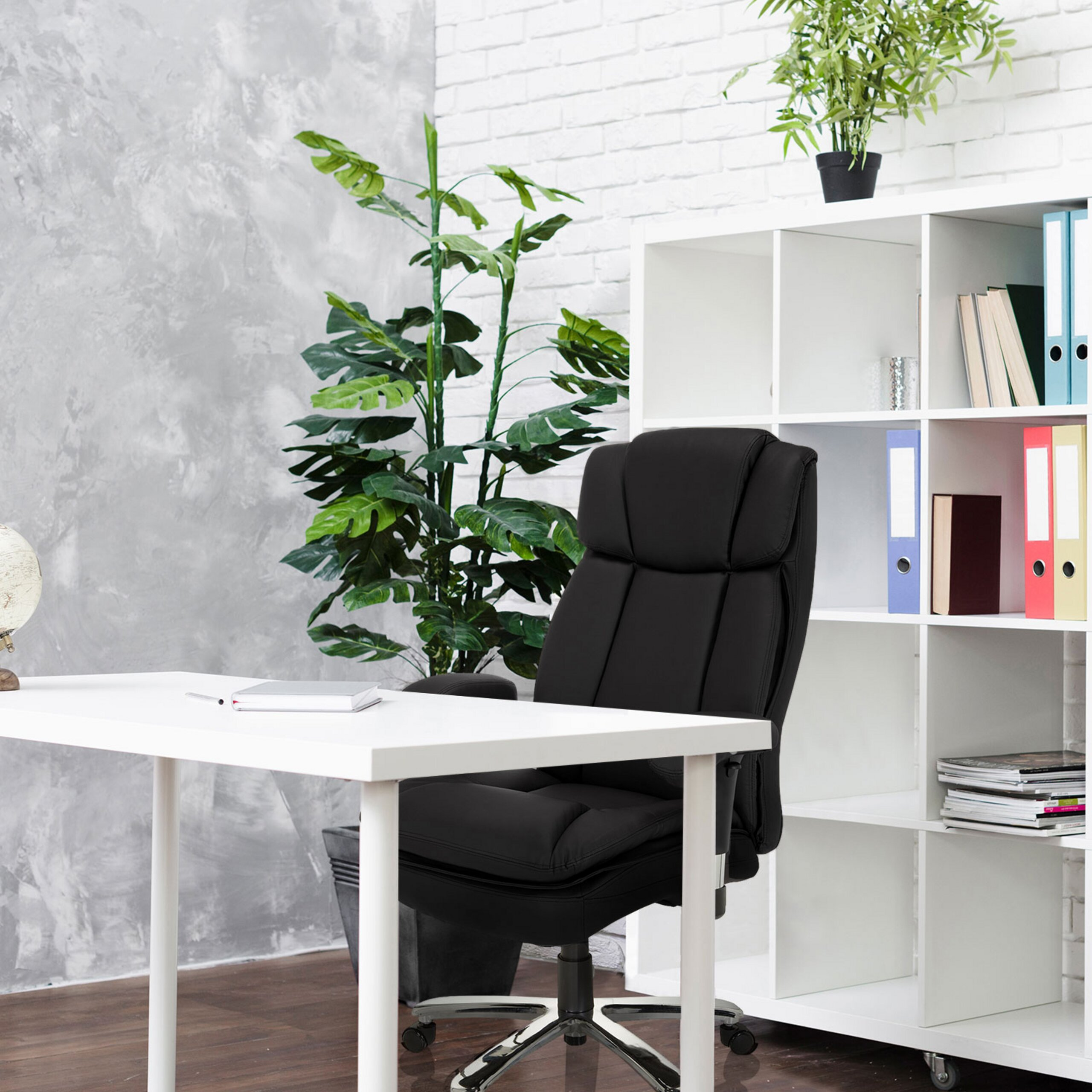 Ein weißer Schreibtisch mit schwarzem Bürostuhl und weißem Regal, dekoriert mit Pflanzen.