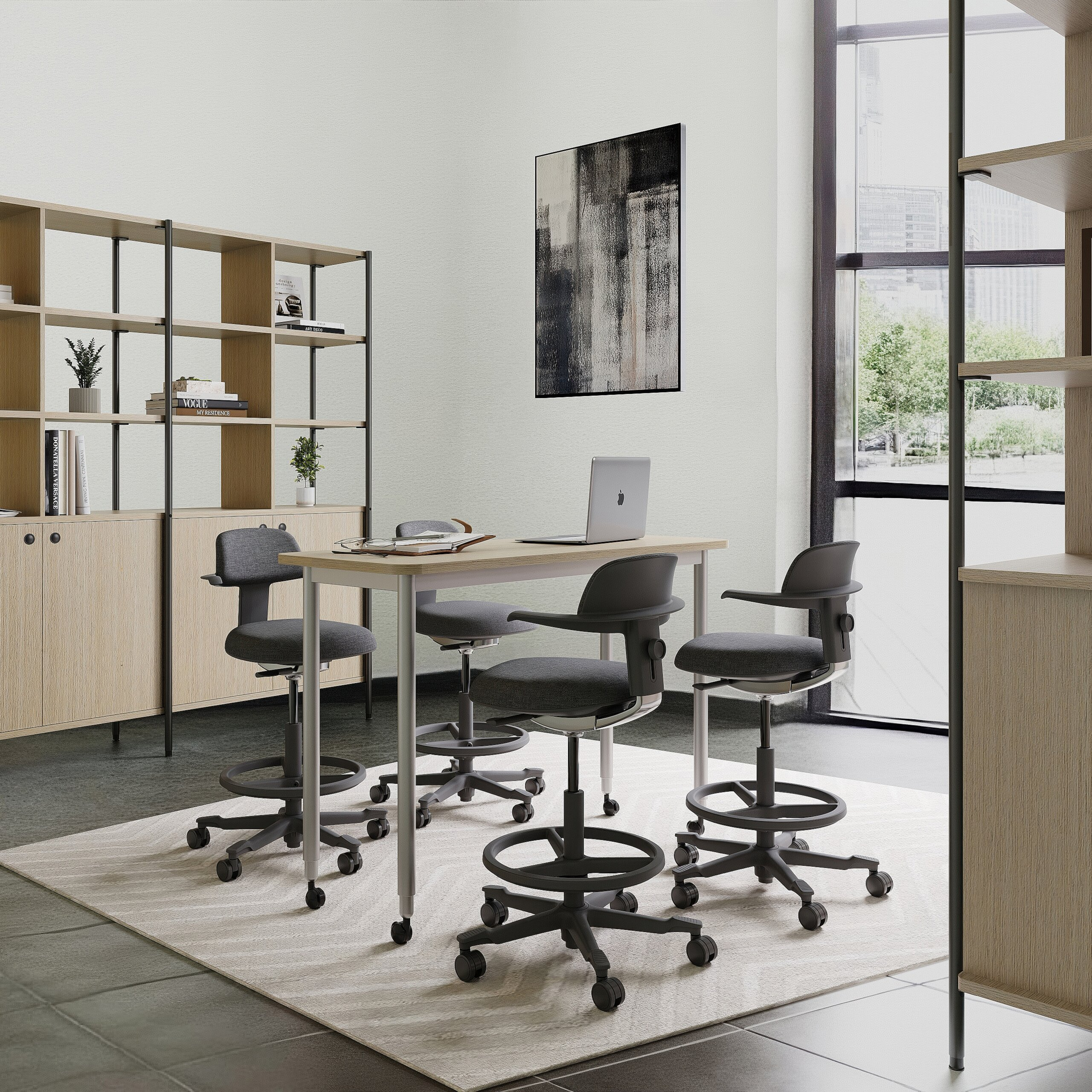 Modernes Büro mit höhenverstellbaren Stühlen, einem Holztisch, Laptop und großen Fenstern mit Stadtblick.