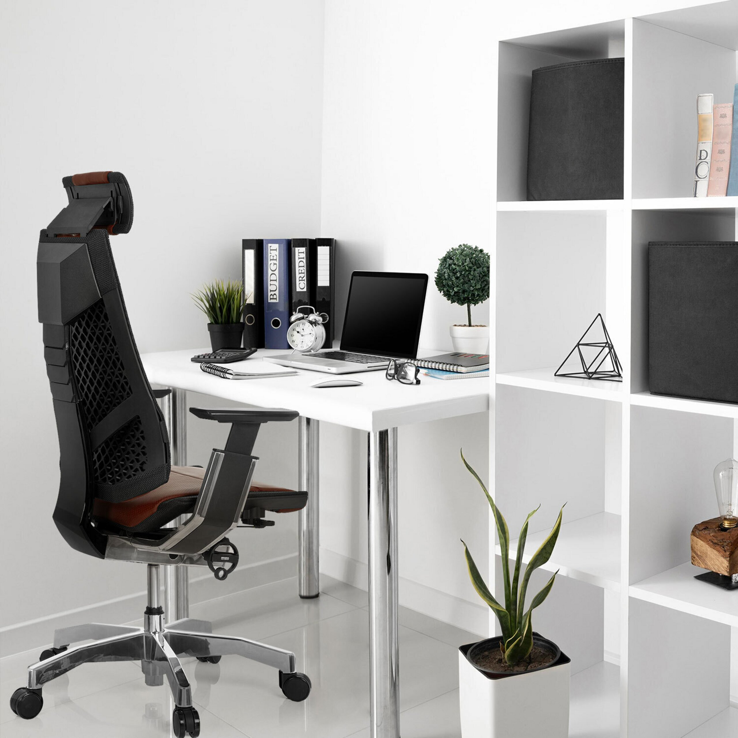 Moderne Schreibtisch-Ecke mit Laptop, schwarzem Bürostuhl, weißen Regalen und Pflanzen.