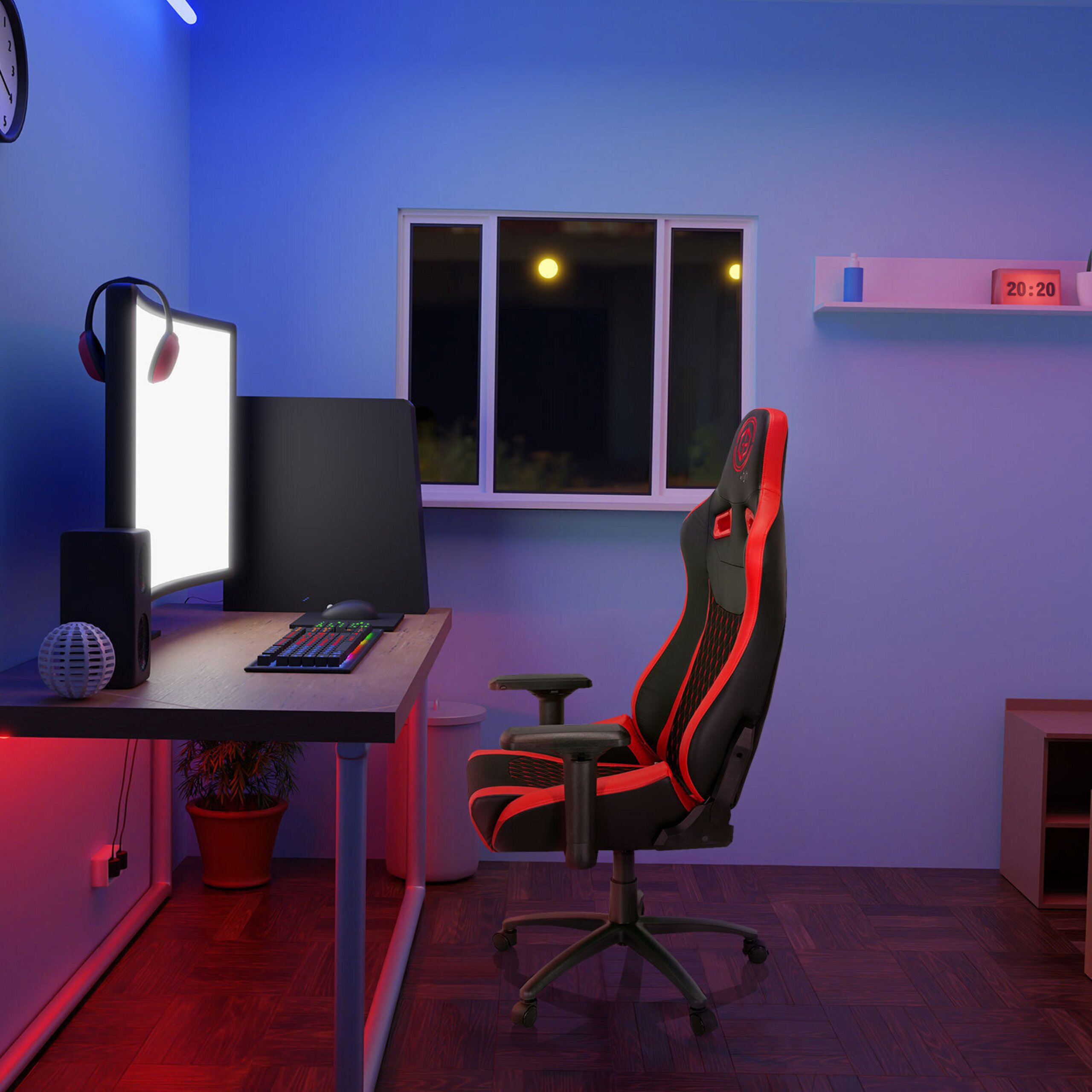 Ein blau beleuchtetes Gamer-Zimmer mit Schreibtisch, rotem Stuhl und Monitor.