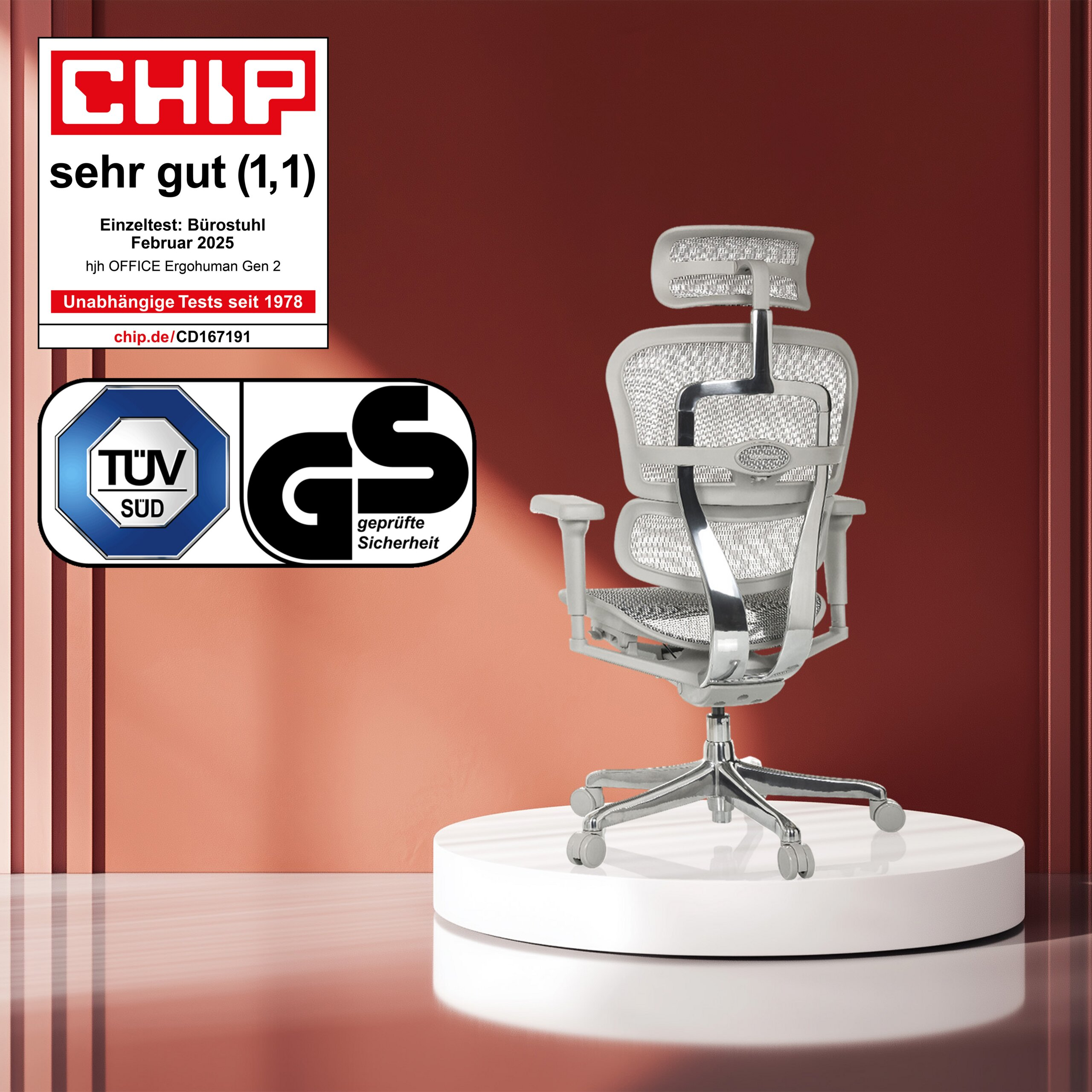 Ein grauer Ergonomie-Bürostuhl steht auf einem weißen Podest vor rotem Hintergrund, mit Siegeln links.