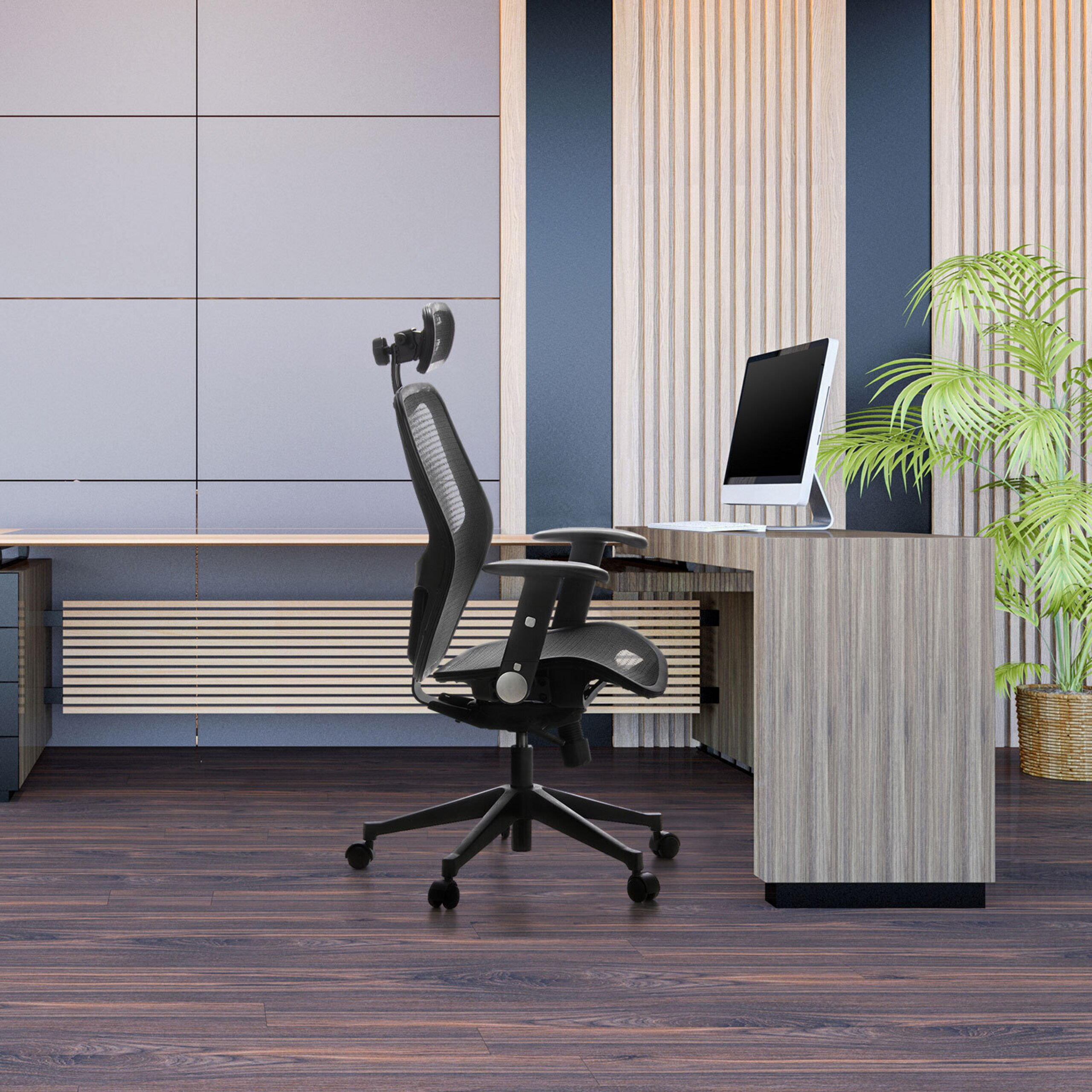 Moderner Arbeitsplatz mit schwarzem Buerostuhl, Computermonitor auf Holztisch und gruener Pflanze vor Holz-Wandpaneelen.
