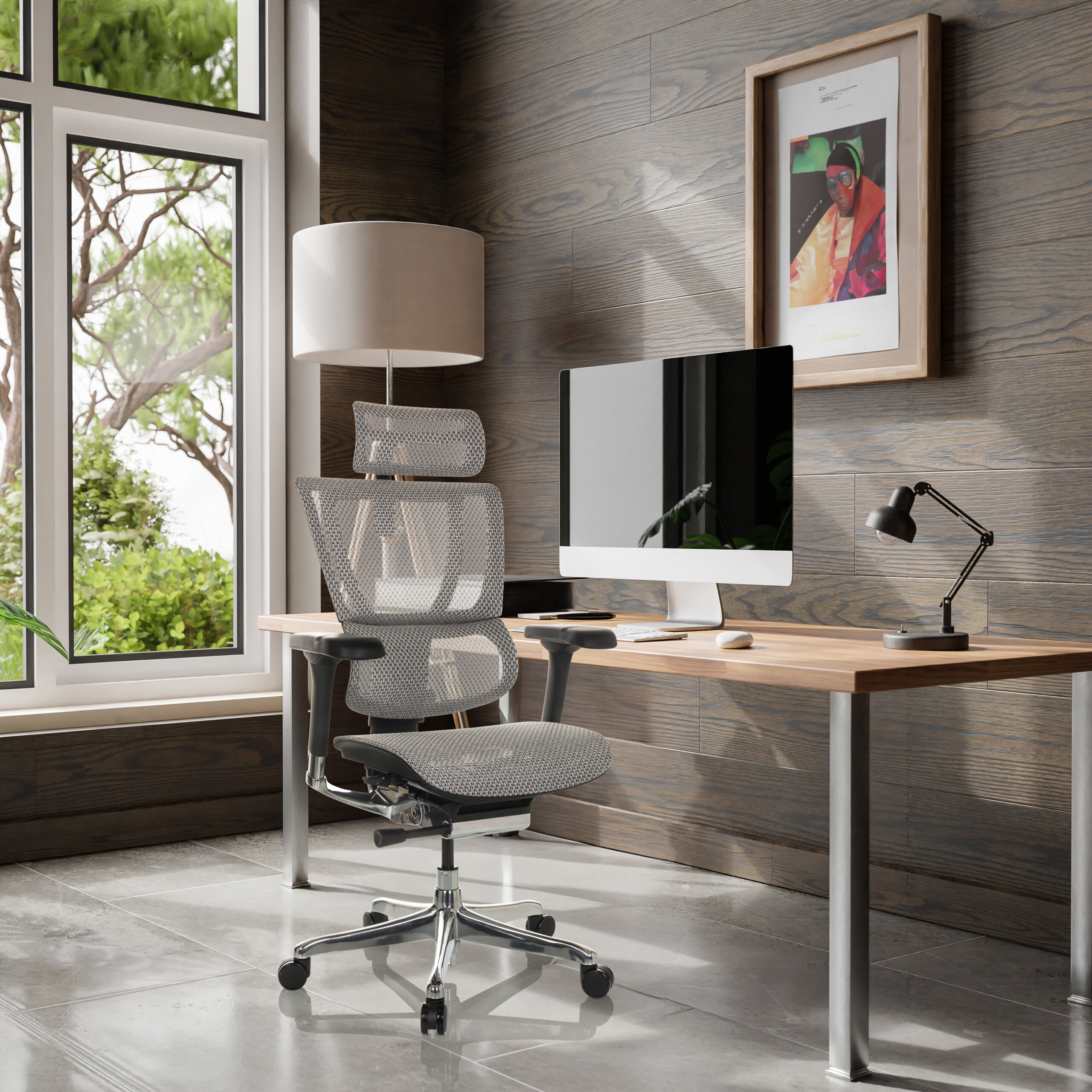 Moderne Arbeitsplatz mit Holzwand, einem Schreibtisch, Computer, ergonomischem Stuhl und großem Fenster mit Grünblick.