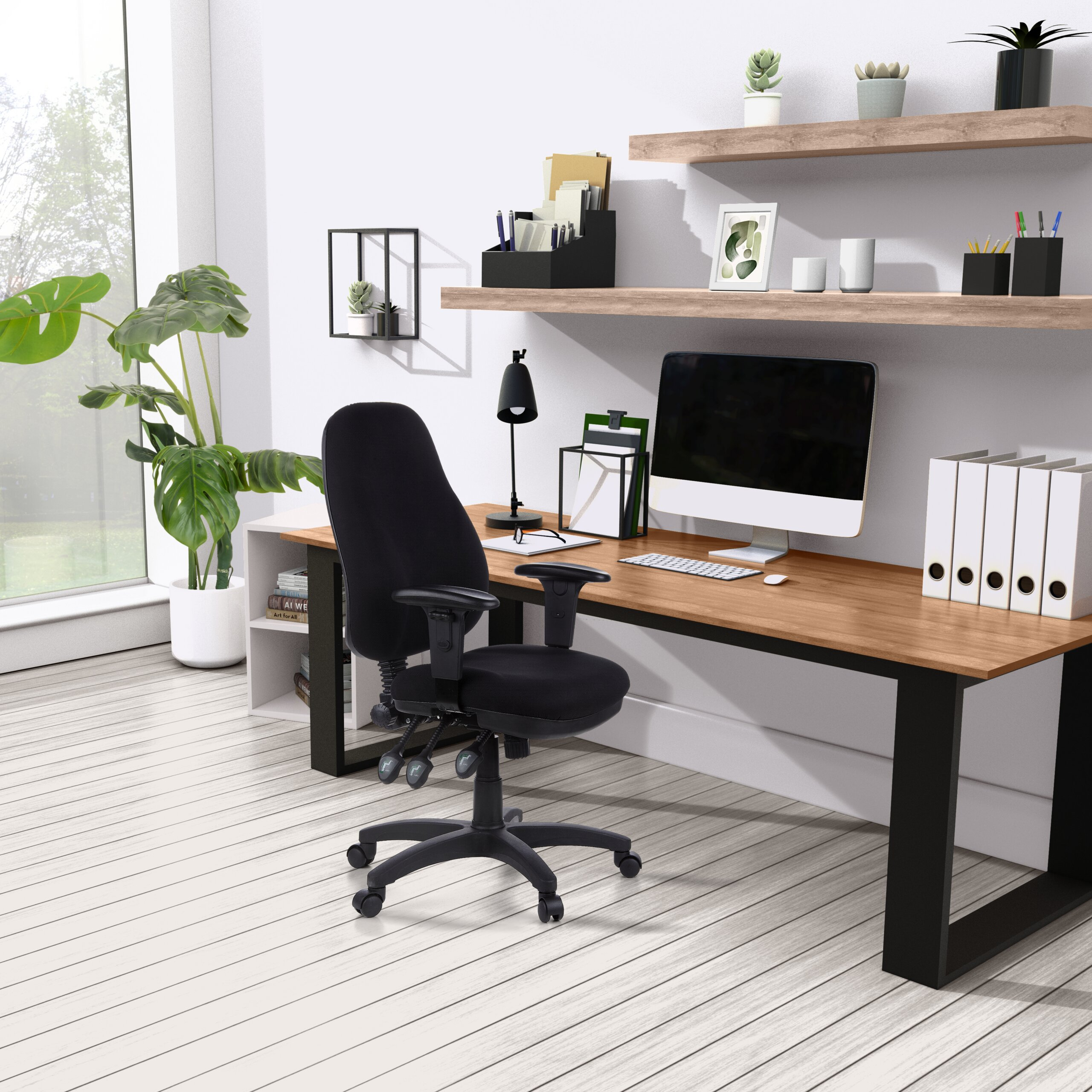 Moderne Büroeinrichtung mit Holztisch, schwarzem Drehstuhl, Computer und Regalen an weißer Wand.