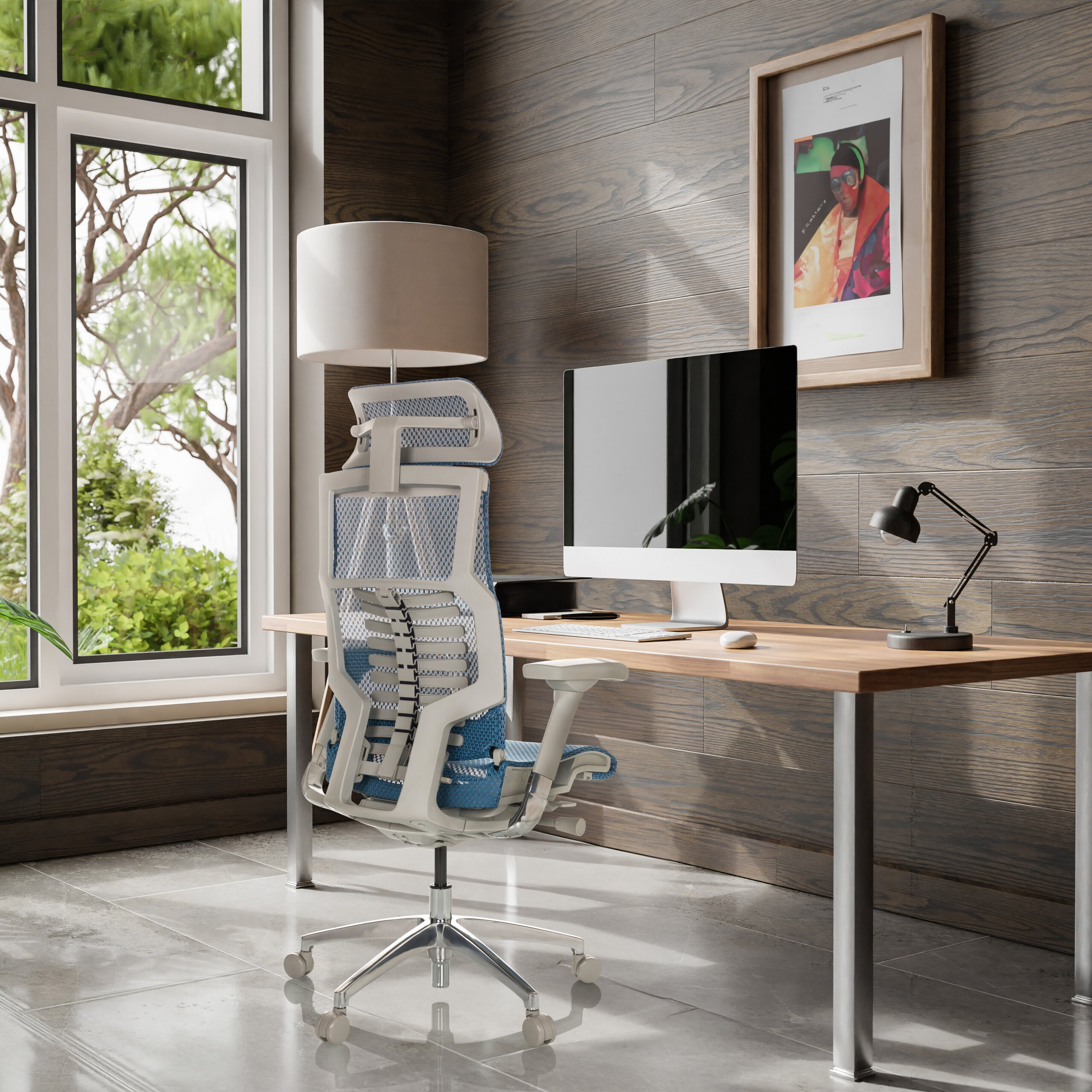 Ein modernes Homeoffice mit einem Holztisch, einem PC, einer Lampe und einem ergonomischen blauen Stuhl vor einem Fenster.
