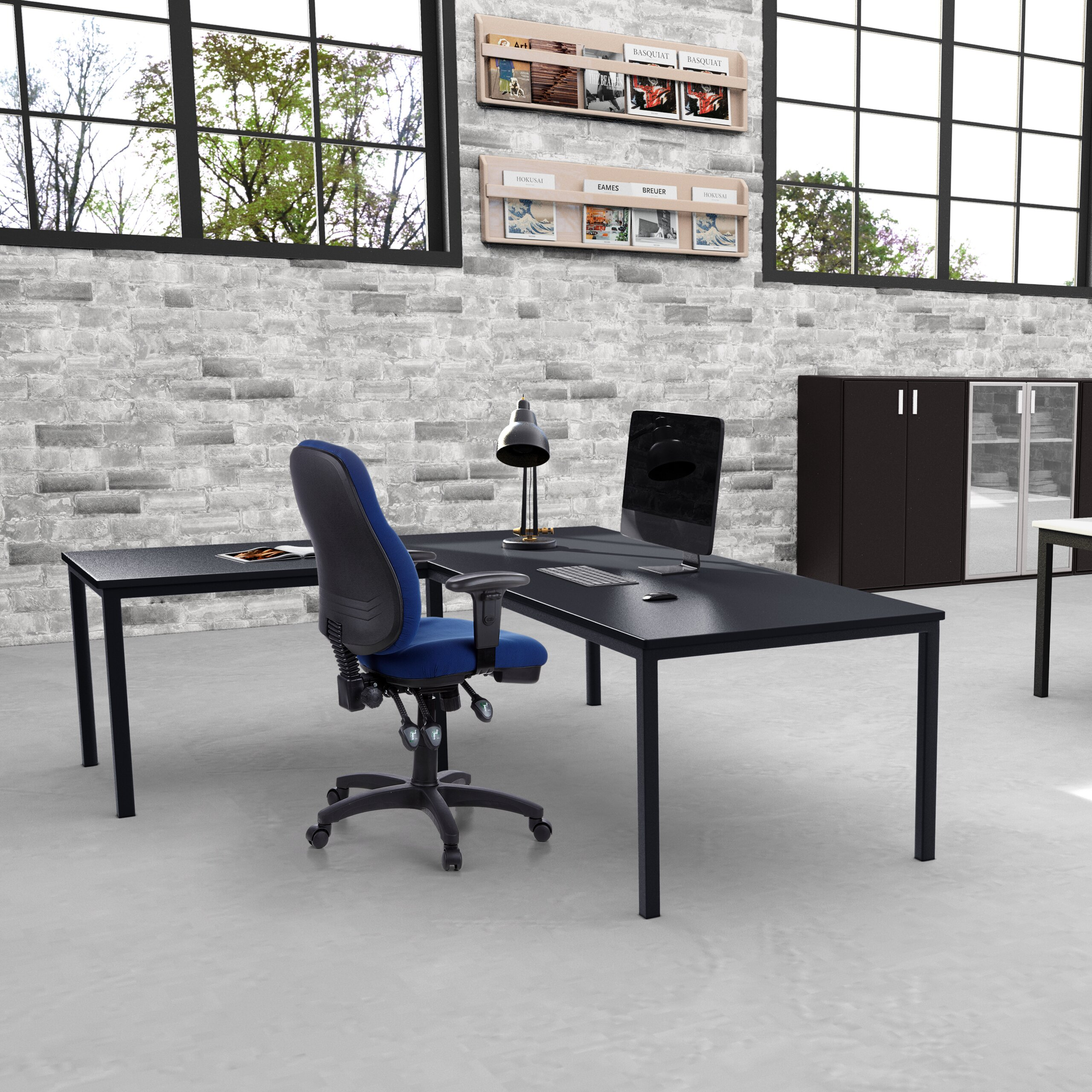 Ein modernes Büro mit einem schwarzen Schreibtisch, blauen Stuhl, Computer, Lampe und Backsteinwand.