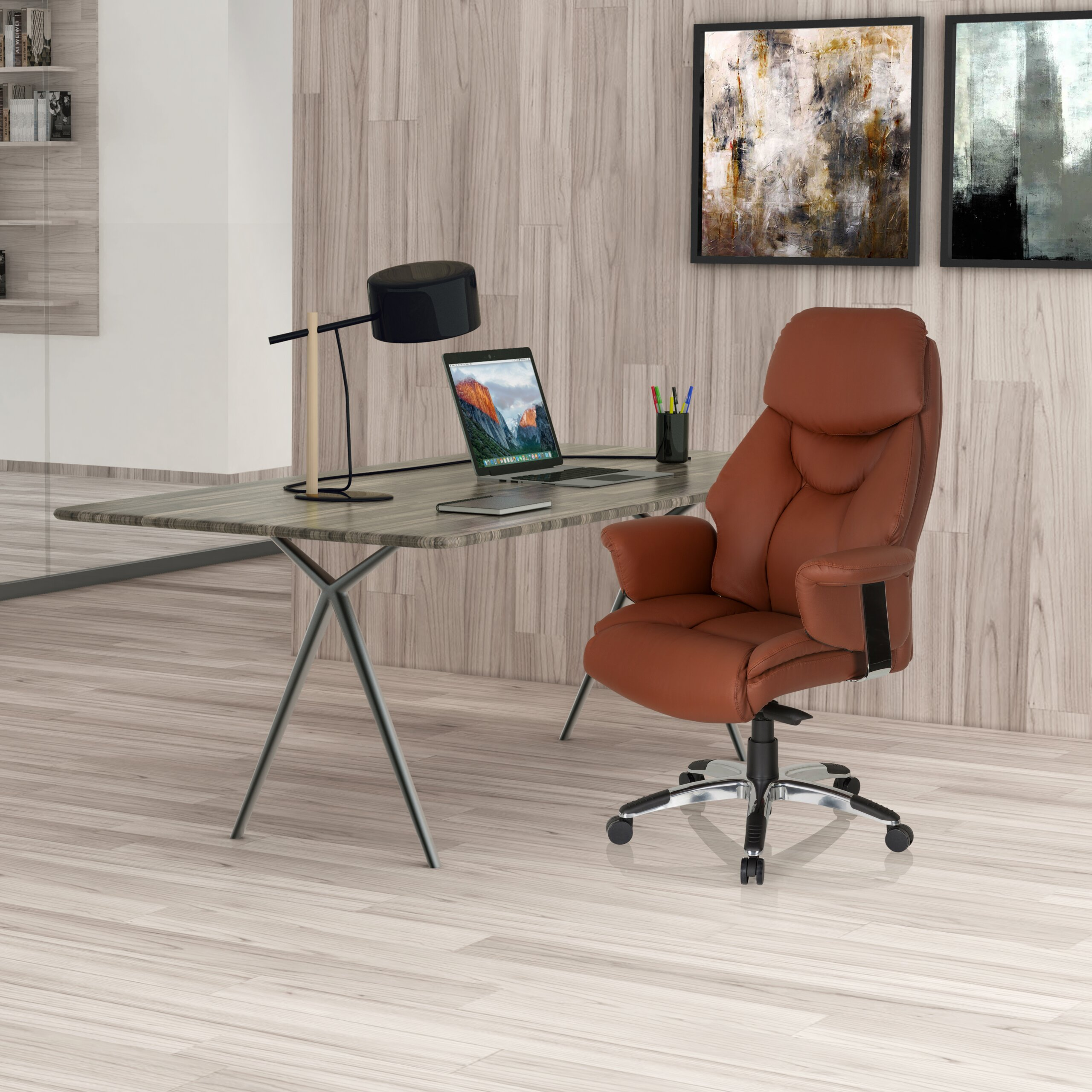 Ein modernes Homeoffice mit braunem Ledersessel, Holztisch, Laptop und Wandkunst.
