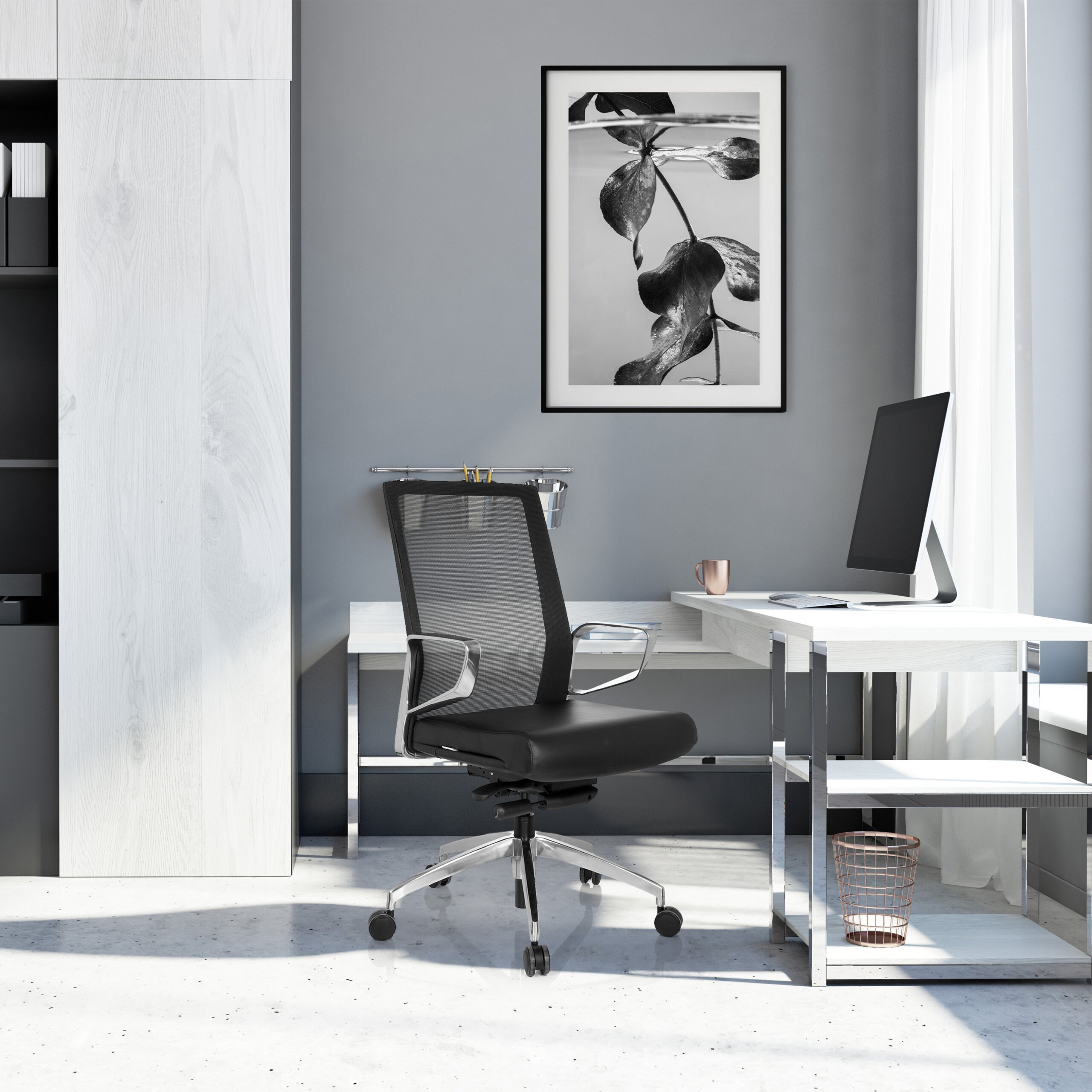Moderne Büro-Ecke mit Schreibtisch, schwarzem Drehstuhl, Computer und gerahmtem Bild an grauer Wand.