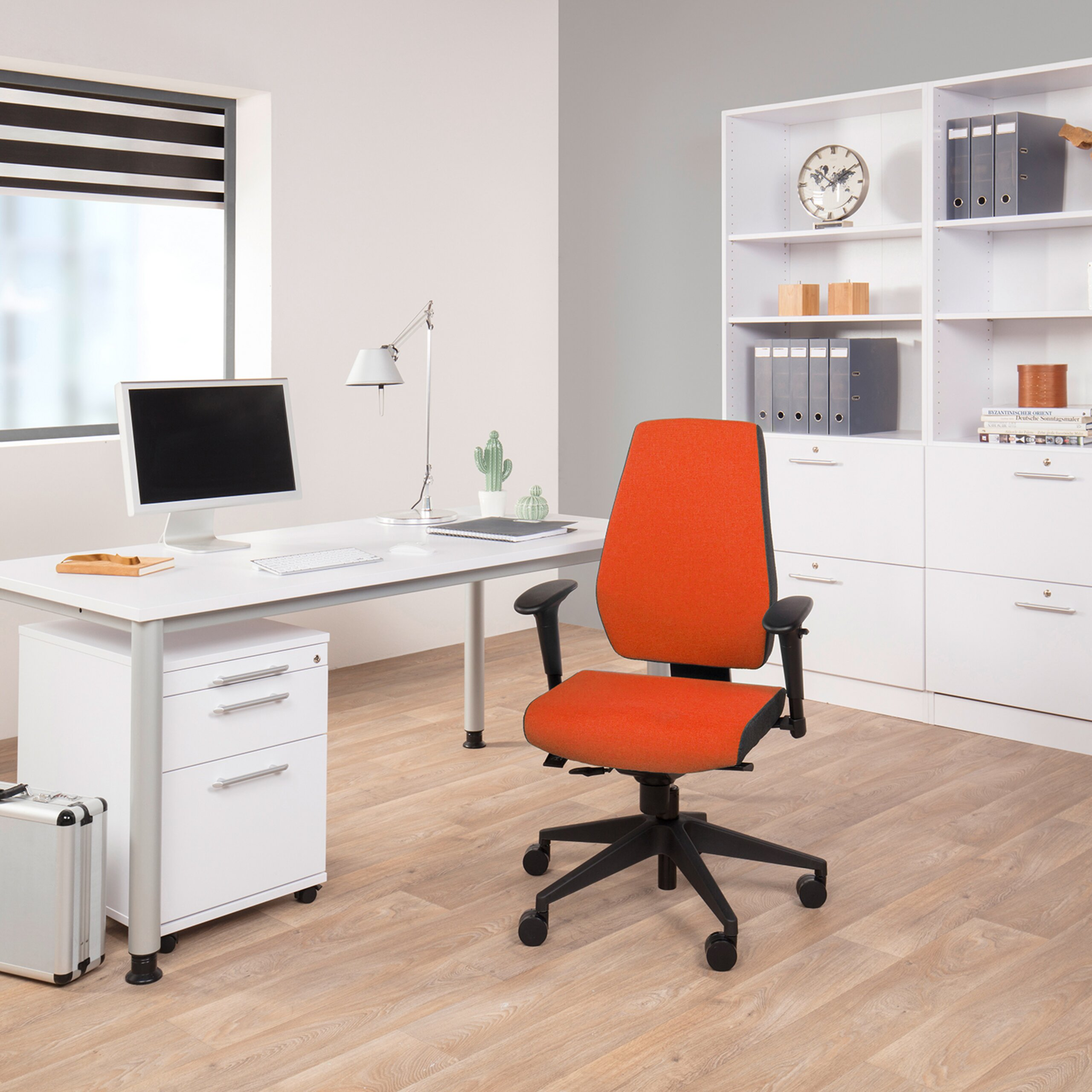 Moderne Büro-Inneneinrichtung mit weißem Schreibtisch, orangefarbenem Stuhl, Computer und großem weißen Regal.