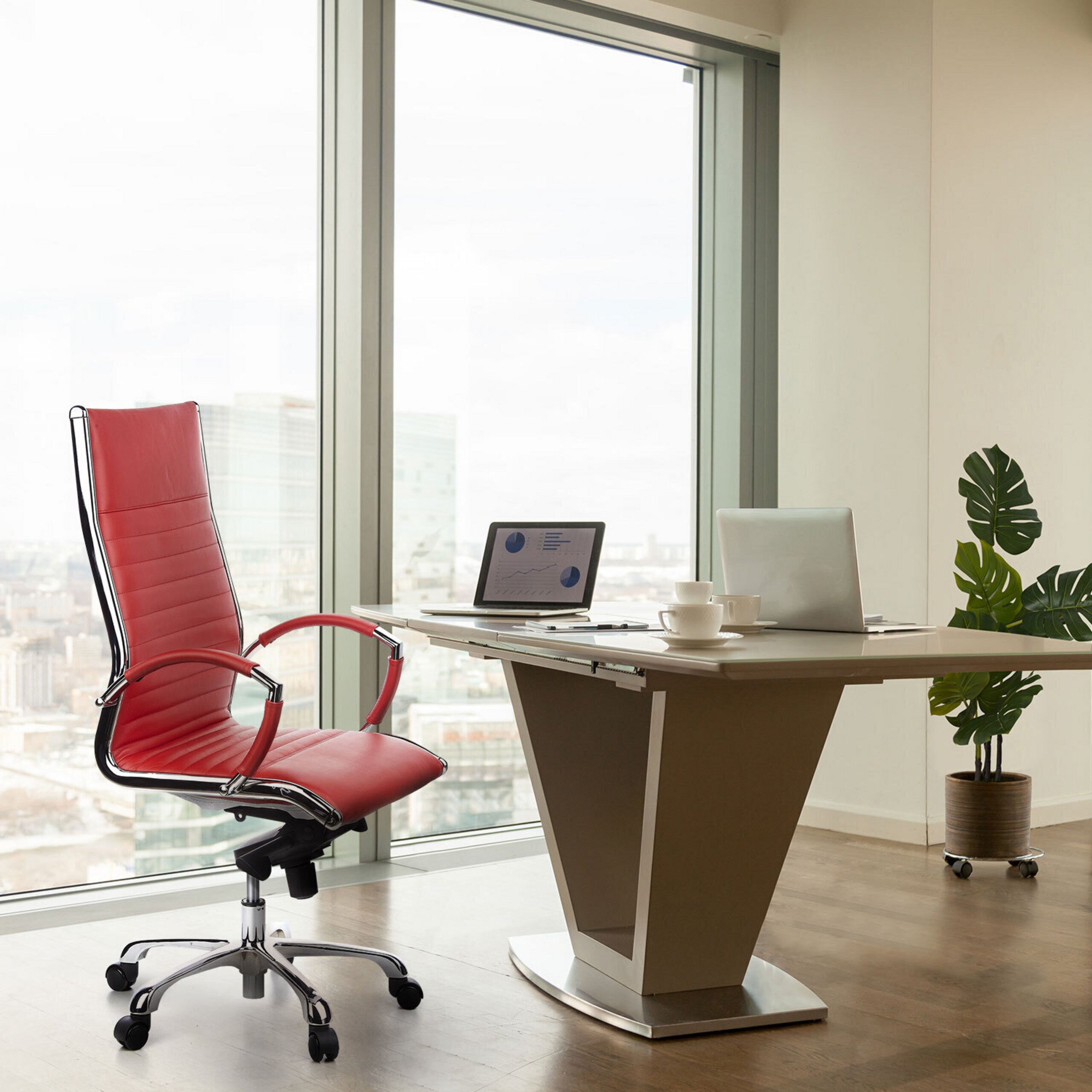 Moderne Büro mit einem roten Stuhl, einem Schreibtisch mit zwei Laptops und einer großen Fensterfront mit Stadtblick.