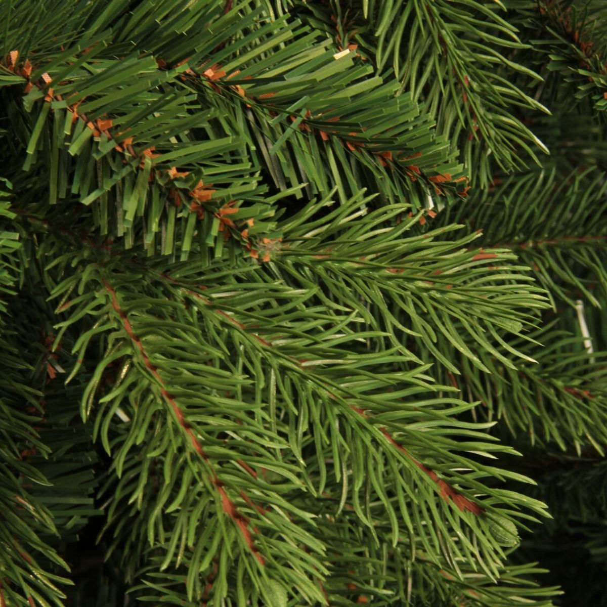 Close-up van kunstmatige groene dennentakken met bruine stengels.