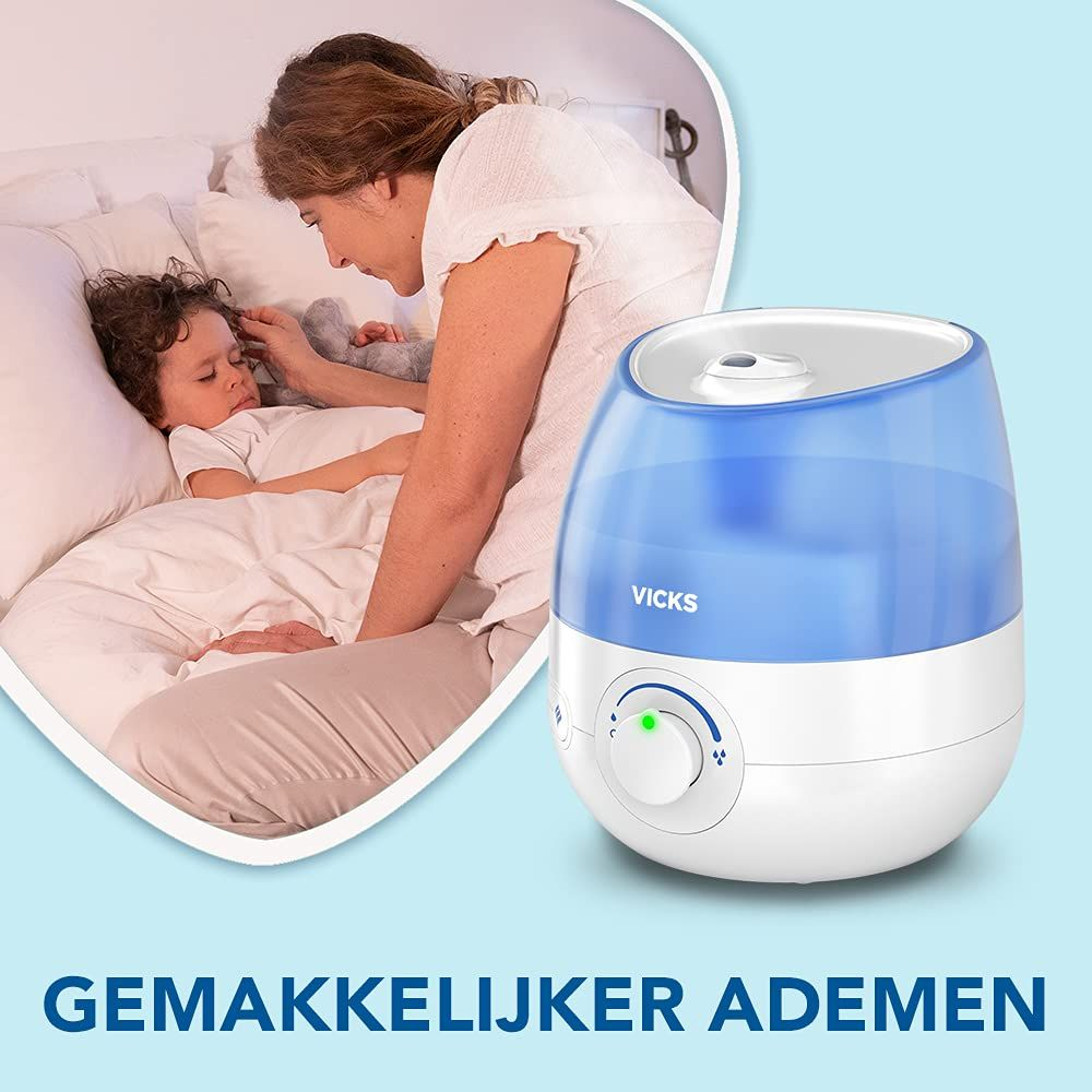Bir anne yatakta hasta bir çocuğu teselli ediyor, yanında mavi bir Vicks hava nemlendirici var.