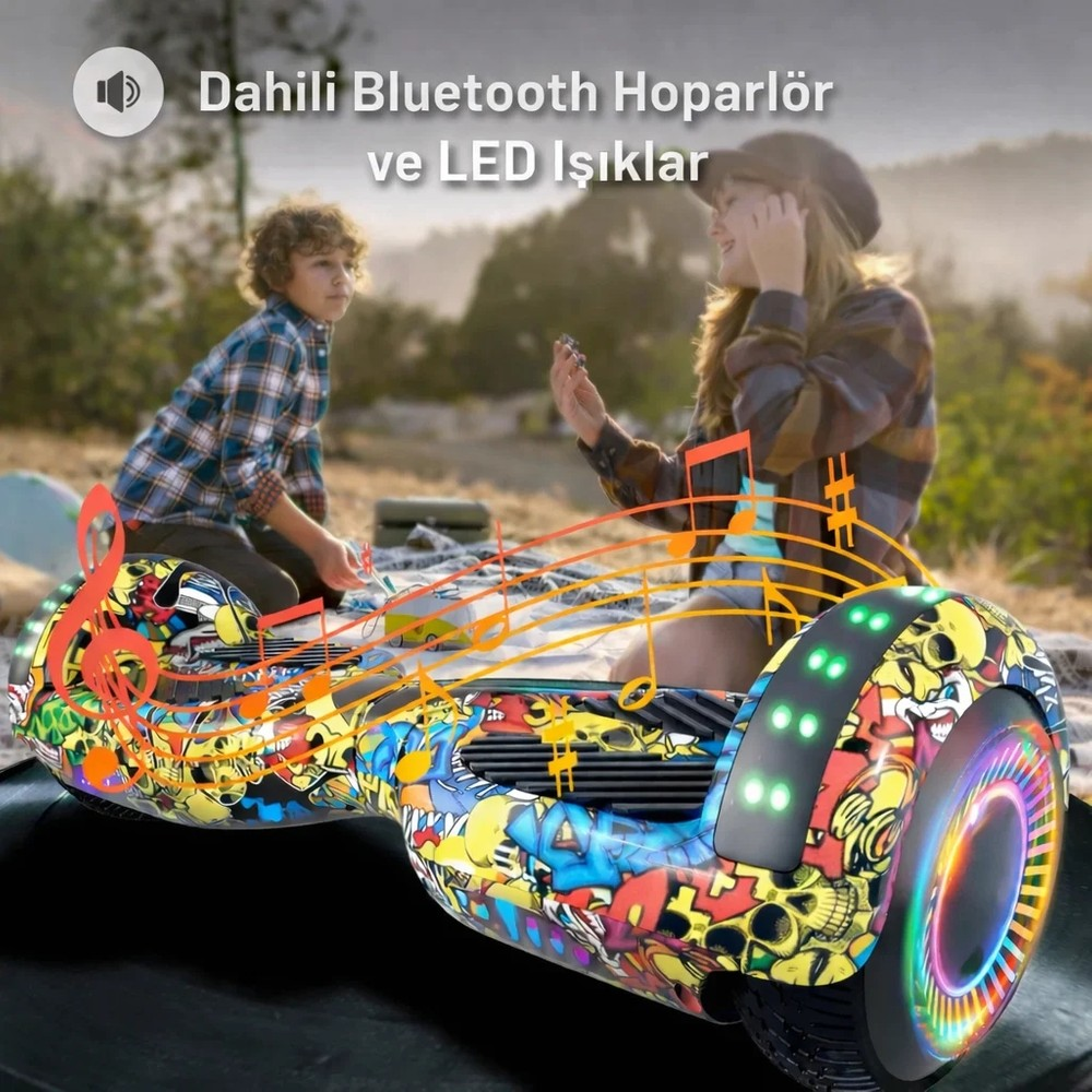 Ön planda renkli desenli hoverboard, arka planda çimenlikte oturan çocuklar.