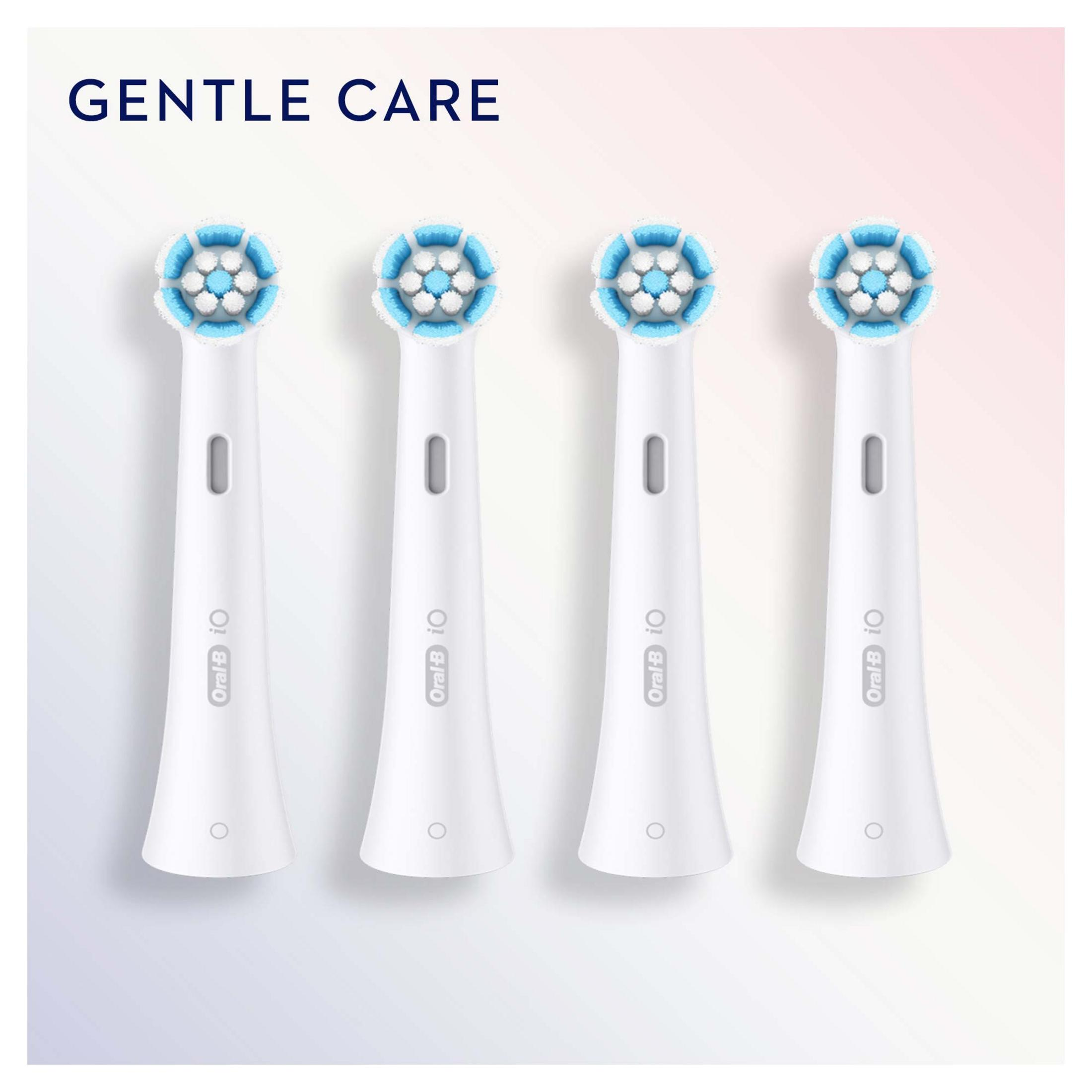 Quattro testine per spazzolino bianche Oral-B iO Gentle Care con setole blu e bianche su sfondo rosa e bianco.