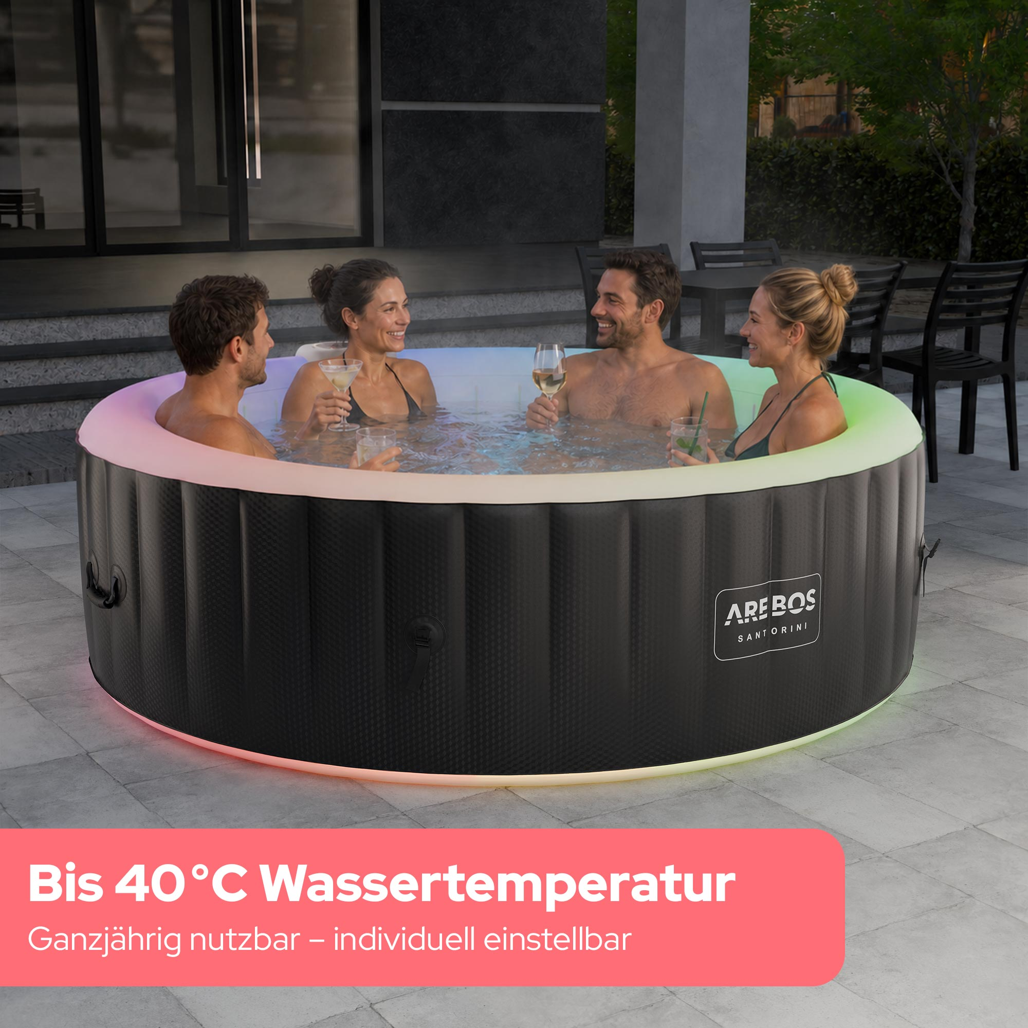 Vier Personen sitzen nachts in einem beleuchteten Whirlpool auf einer Terrasse und trinken Cocktails.