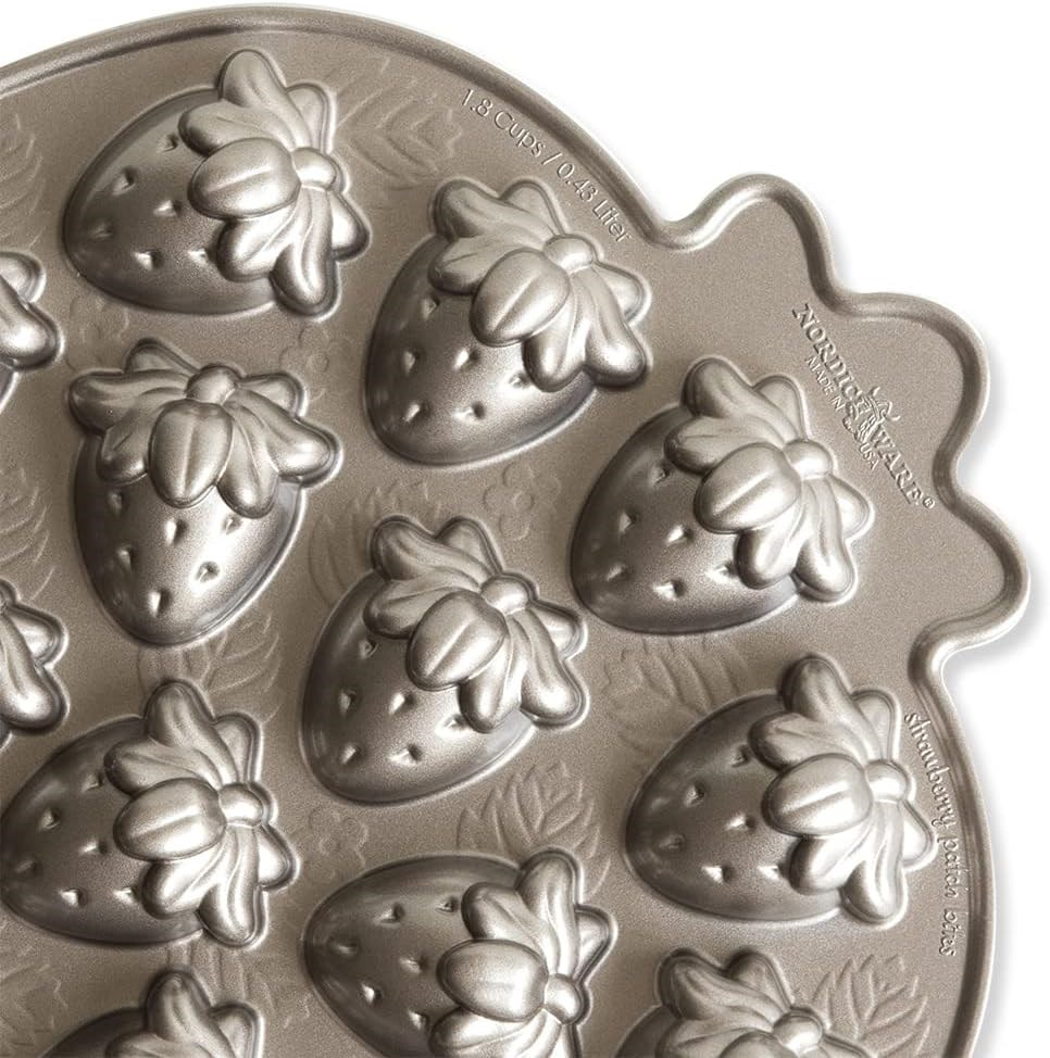 Detaylı çilek ve yaprak şeklinde oyuklara sahip metal Nordic Ware fırın tepsisi.