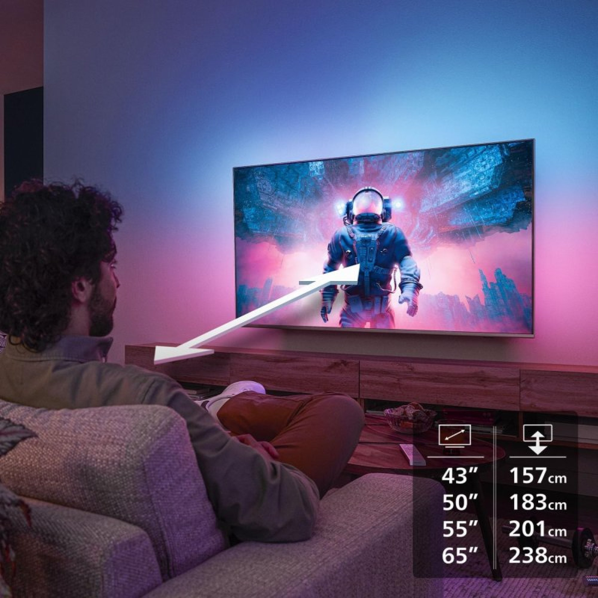 Un homme sur un canapé regarde la télé montrant un astronaute, avec des dimensions de taille en overlay.