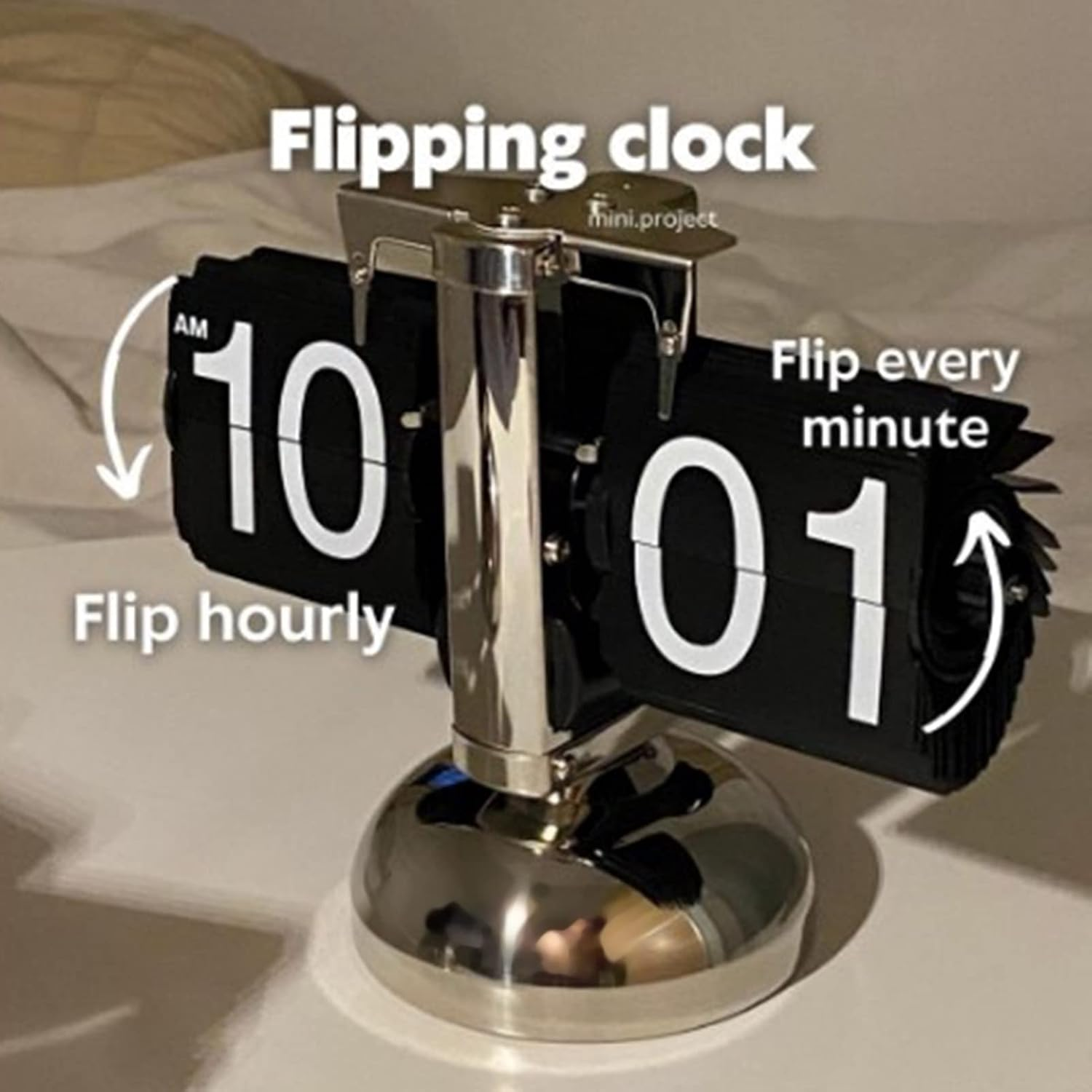 Eine silberne Flip-Uhr zeigt 10:01 an, mit Texten wie "Flipping clock" und "Flip hourly" auf dem Bild.