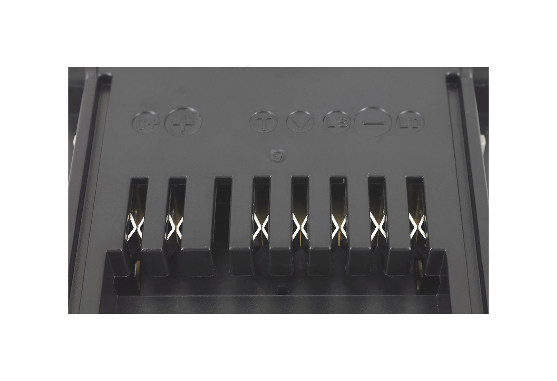 Nahaufnahme eines schwarzen Batterieanschlusses mit sichtbaren Metallkontakten und geprägten Symbolen.