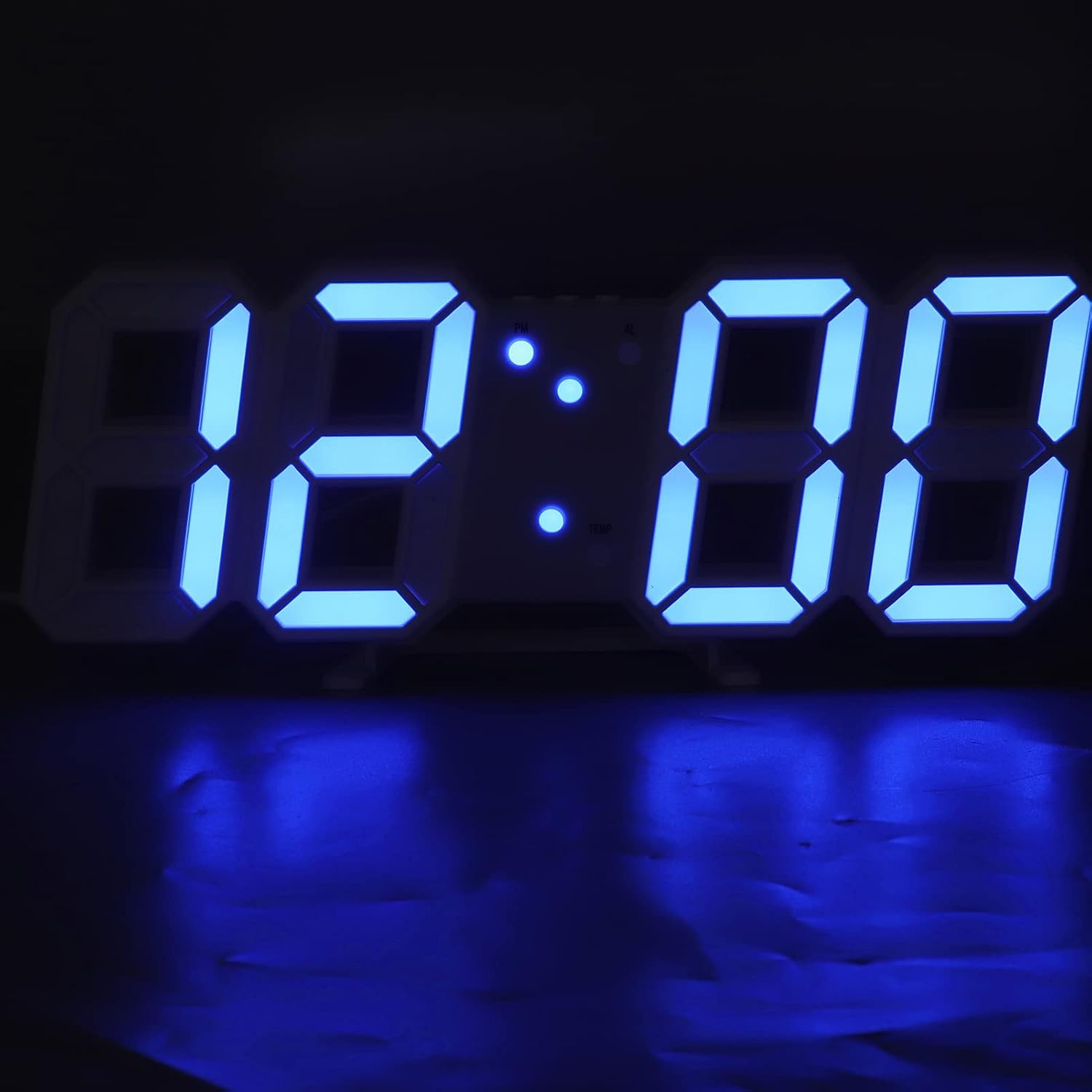 Eine blaue LED-Digitaluhr zeigt 12:00 Uhr in einem dunklen Raum.