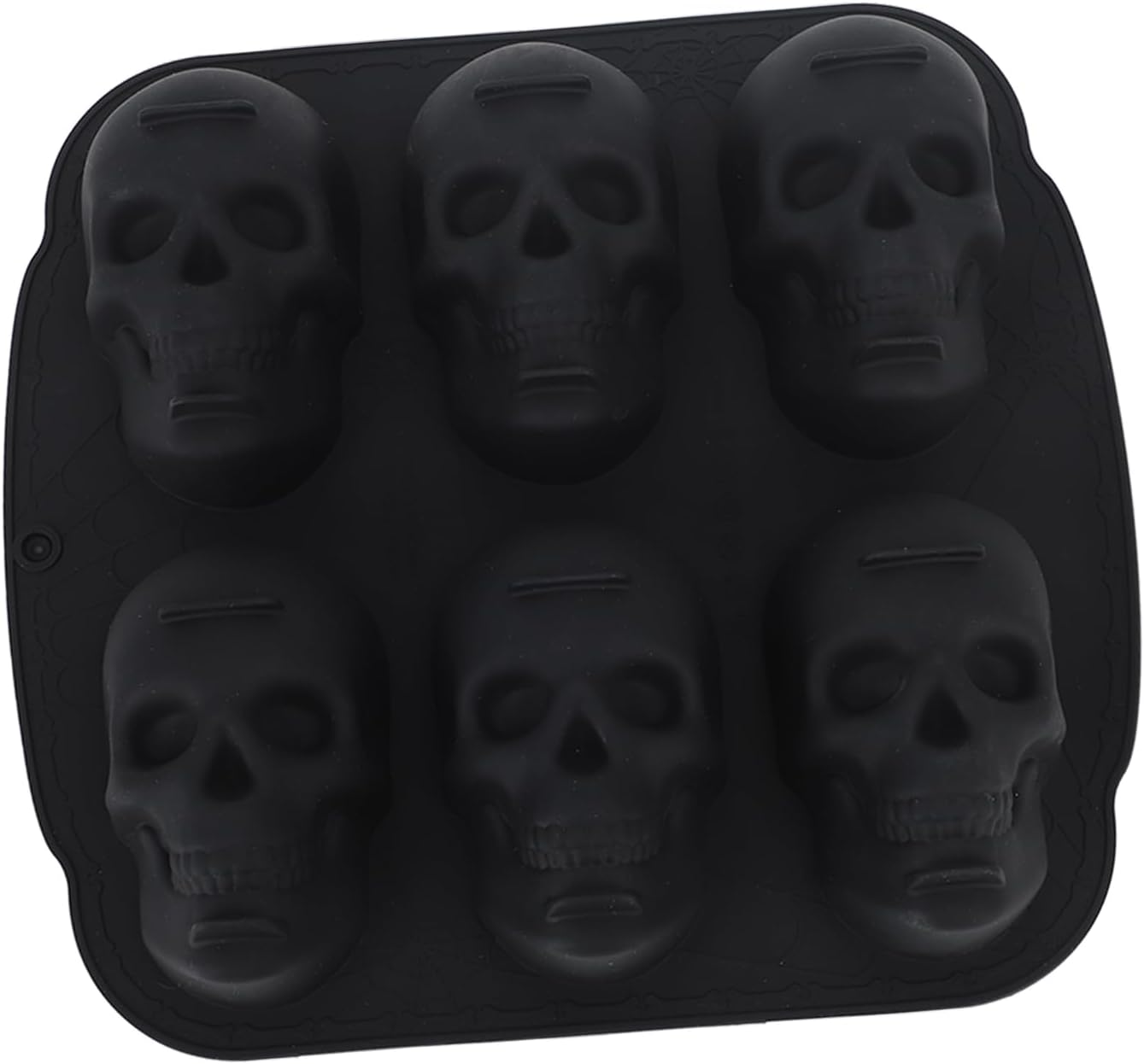 Eine schwarze Silikonform mit sechs totenkopf förmigen Mulden.