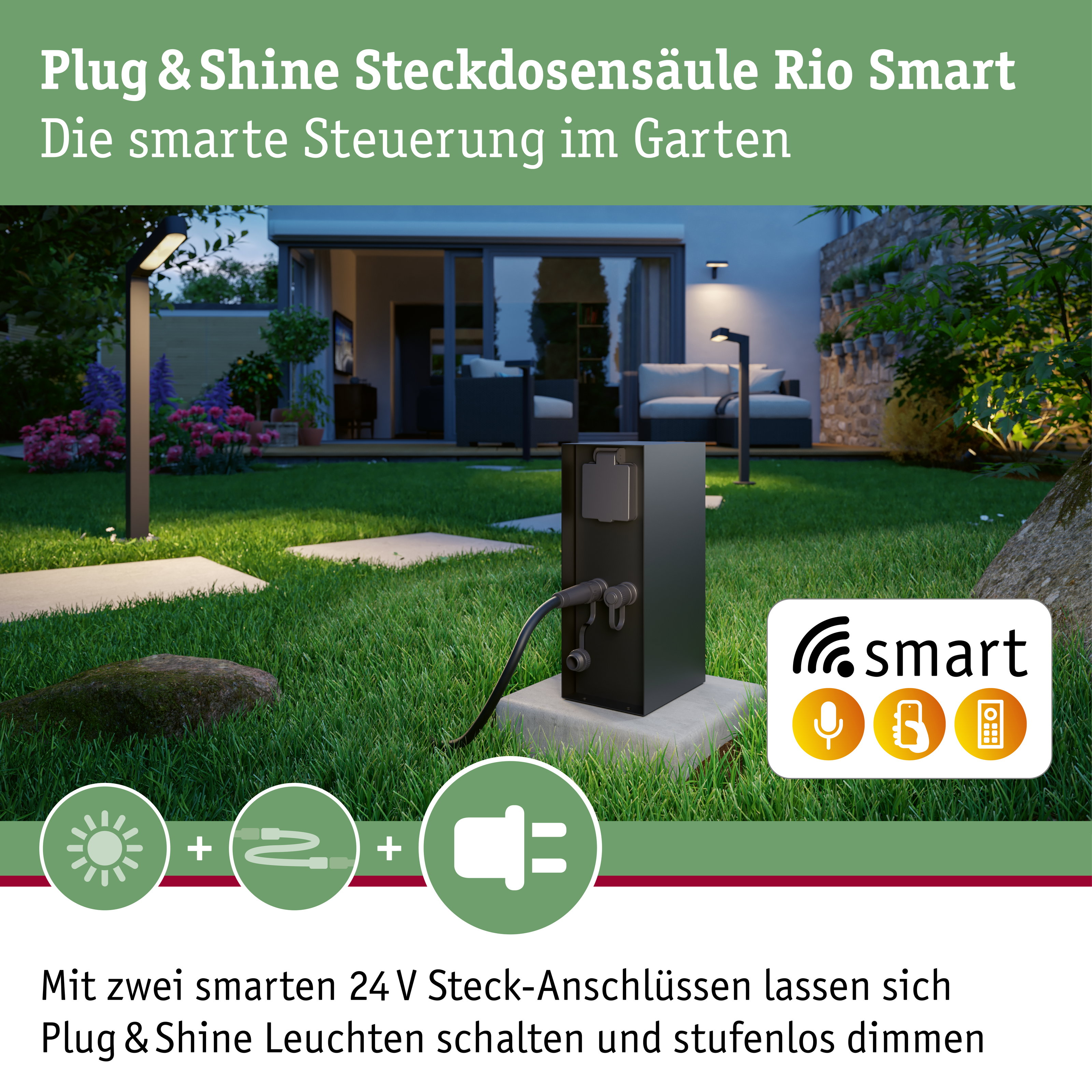 Eine schwarze Steckdosensäule steht im grünen Garten vor einer beleuchteten Terrasse mit Möbeln.
