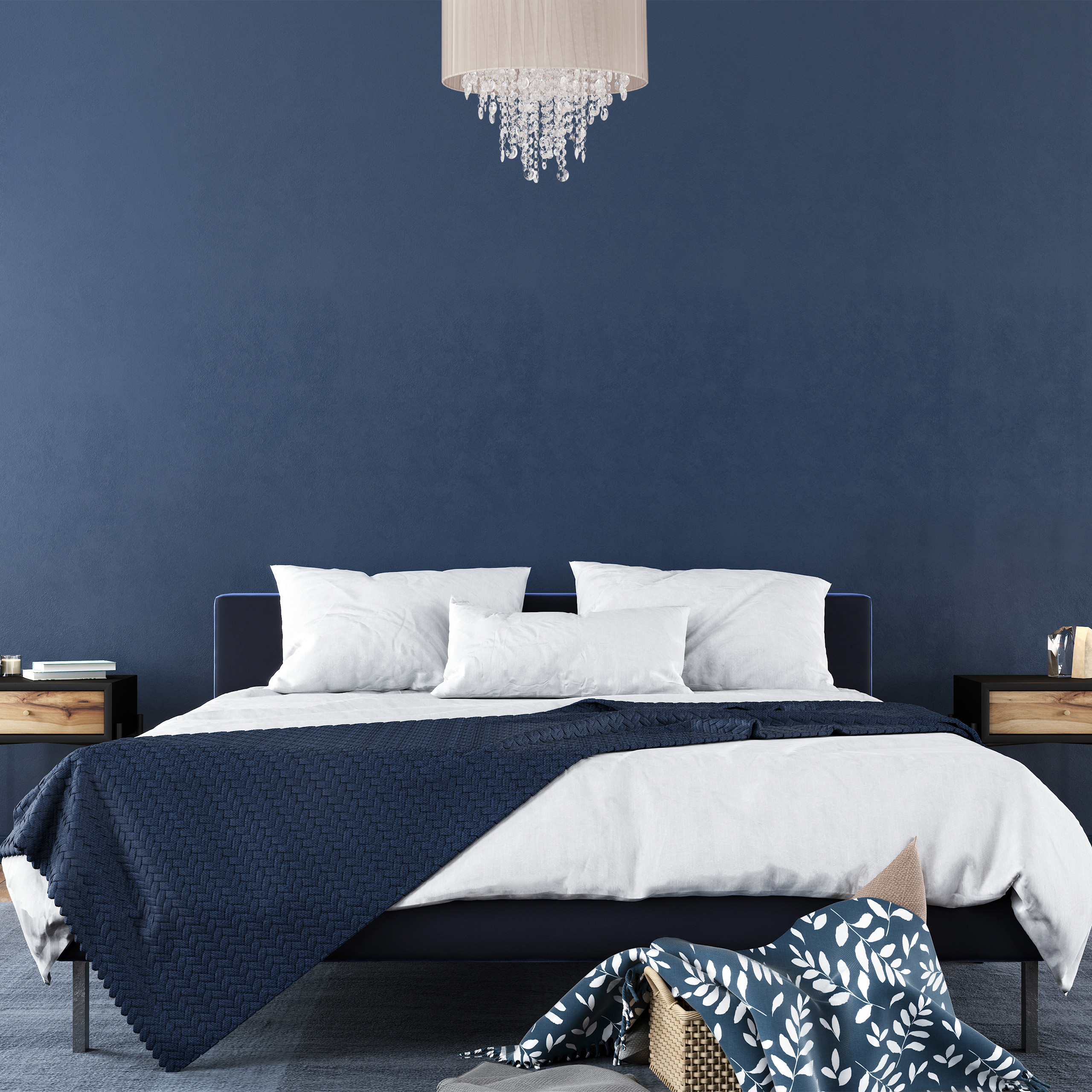 Schlafzimmer mit dunkelblauer Wand, Bett mit weißen Kissen, blauer Decke und Kristallkronleuchter oben.