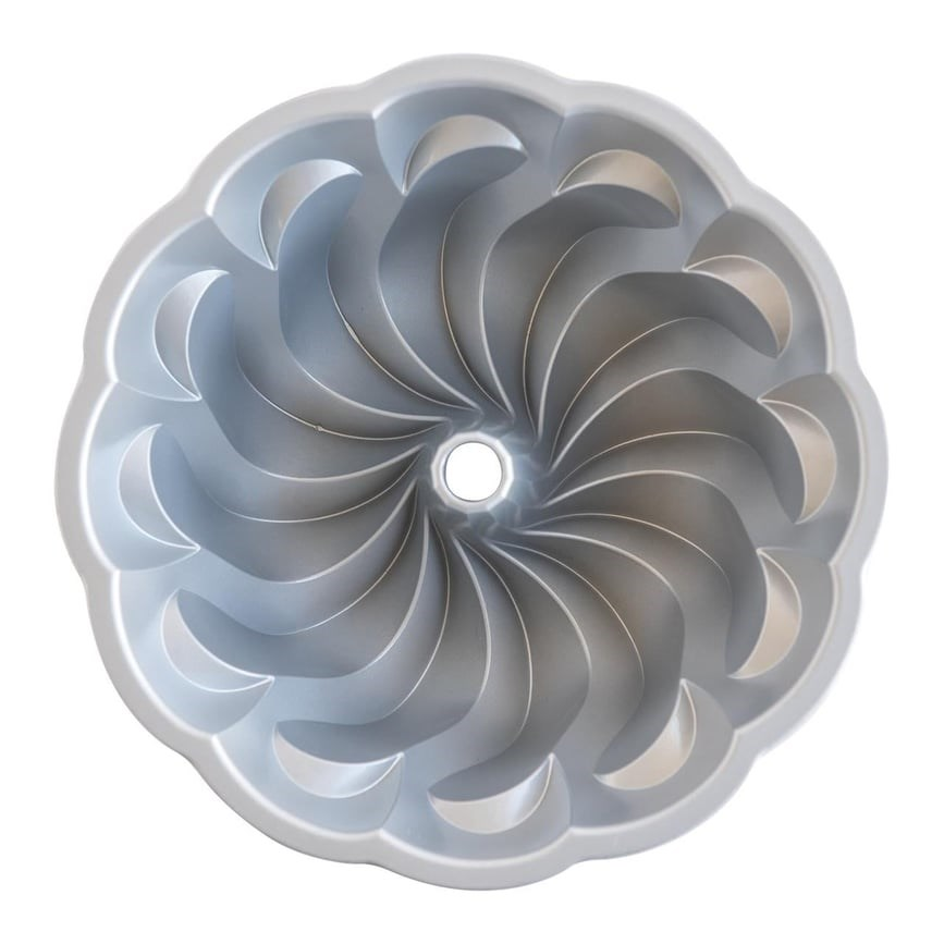 Beyaz arka planda spiral tasarımlı ve merkezinde delik bulunan gri metal kek kalıbının üstten görünümü.