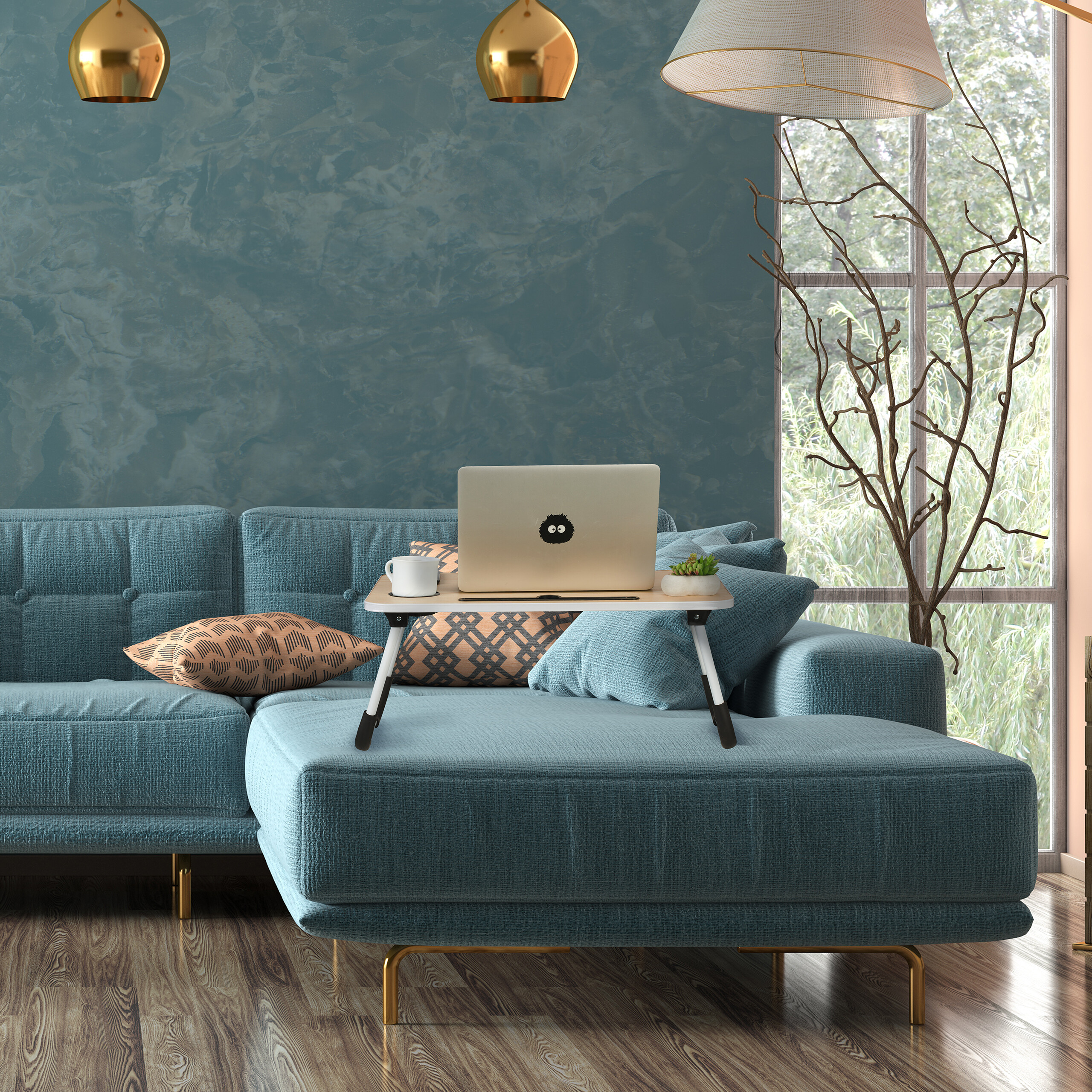 Ein blauer L-Sofa mit Laptop-Ständer und Kissen vor einer blauen Wand und großem Fenster.