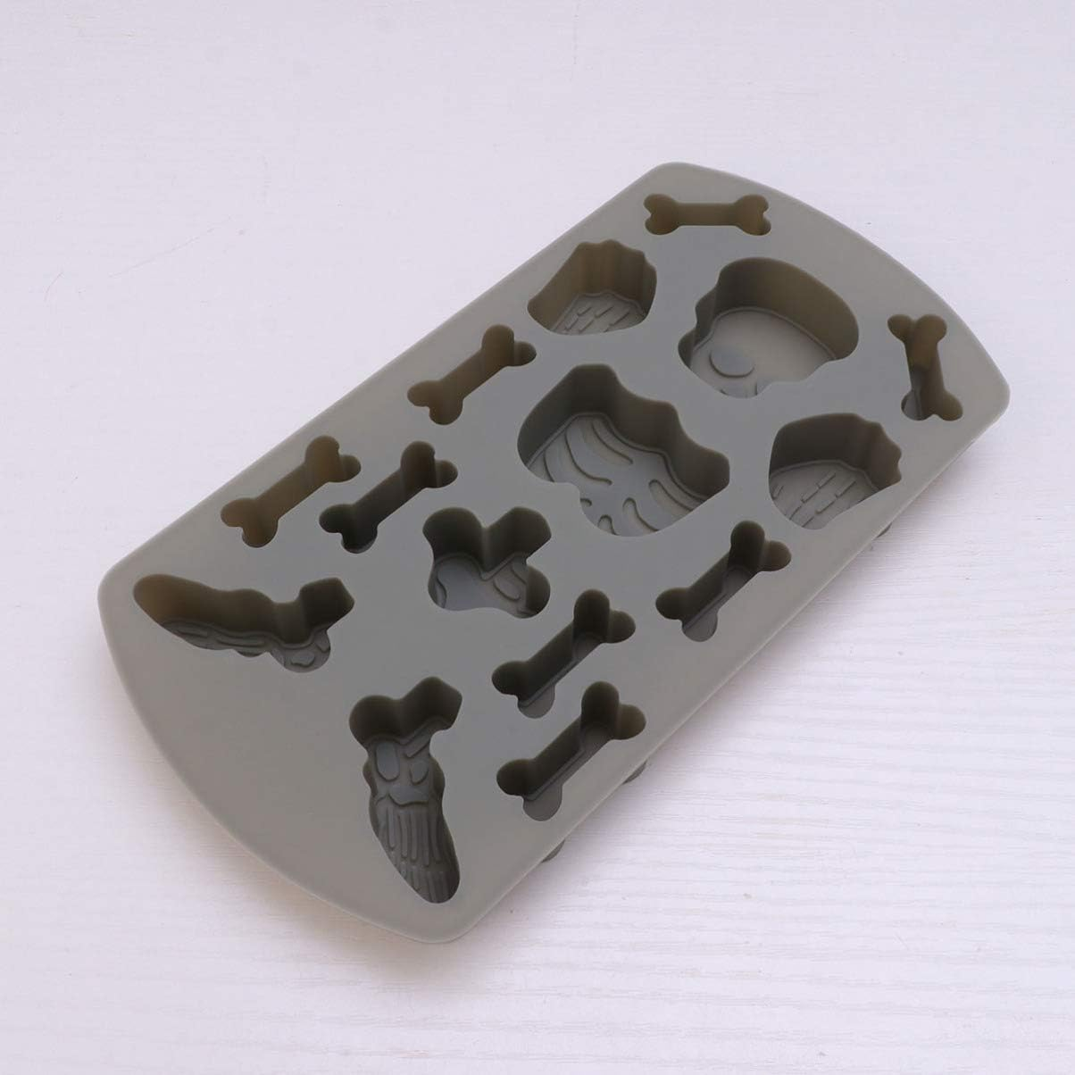 Graue Silikonform mit Knochen-, Schädel- und Fossilienmotiven auf einer weißen Oberfläche.