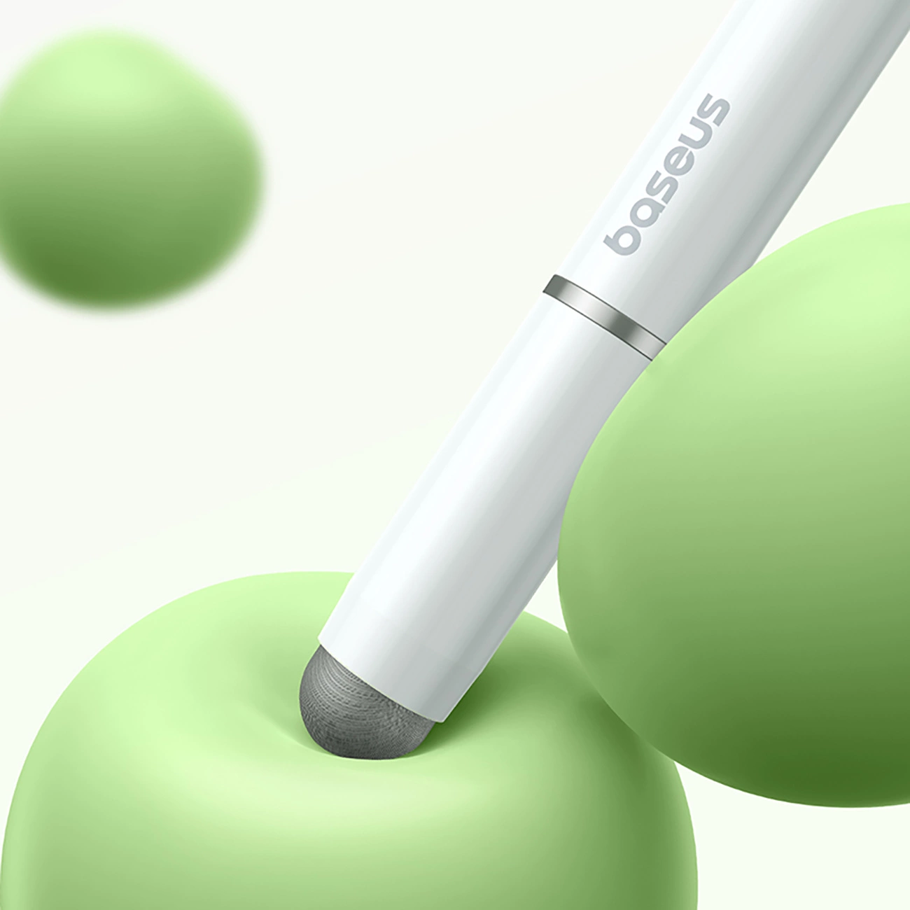Ein weißer Baseus-Stift berührt eine weiche grüne Kugel, umgeben von anderen grünen Kugeln vor hellem Hintergrund.