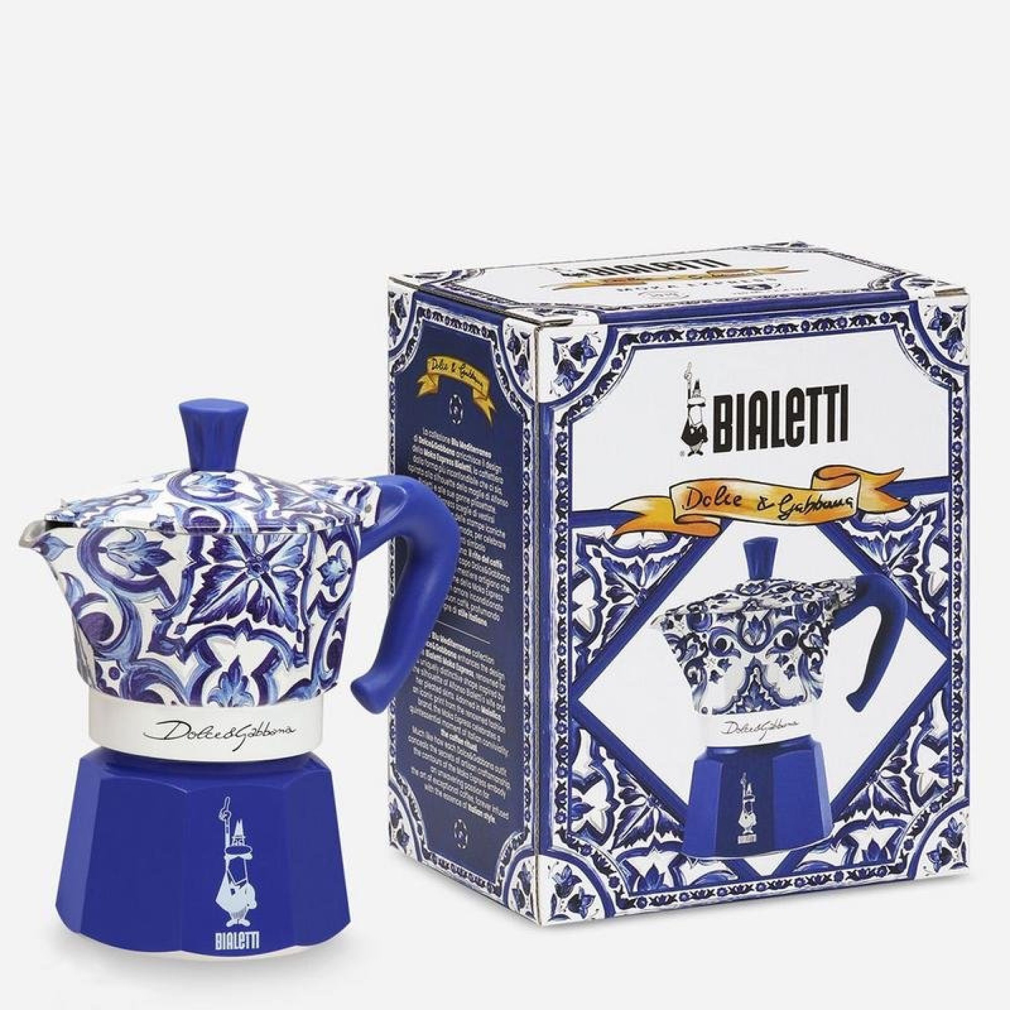 Una moka blu e bianca con motivo maiolica accanto alla sua confezione regalo.
