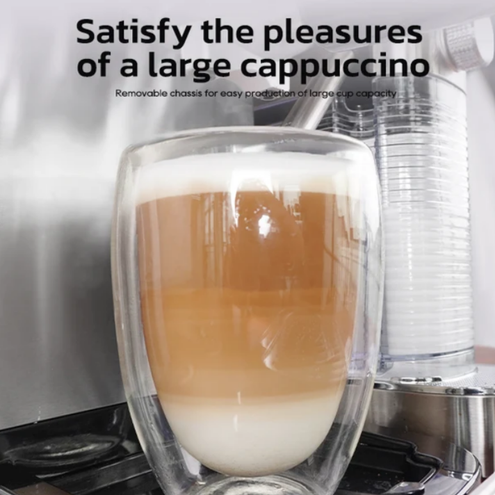 Ein großes Glas Cappuccino mit geschichteter Milch und Kaffee vor einer Kaffeemaschine.