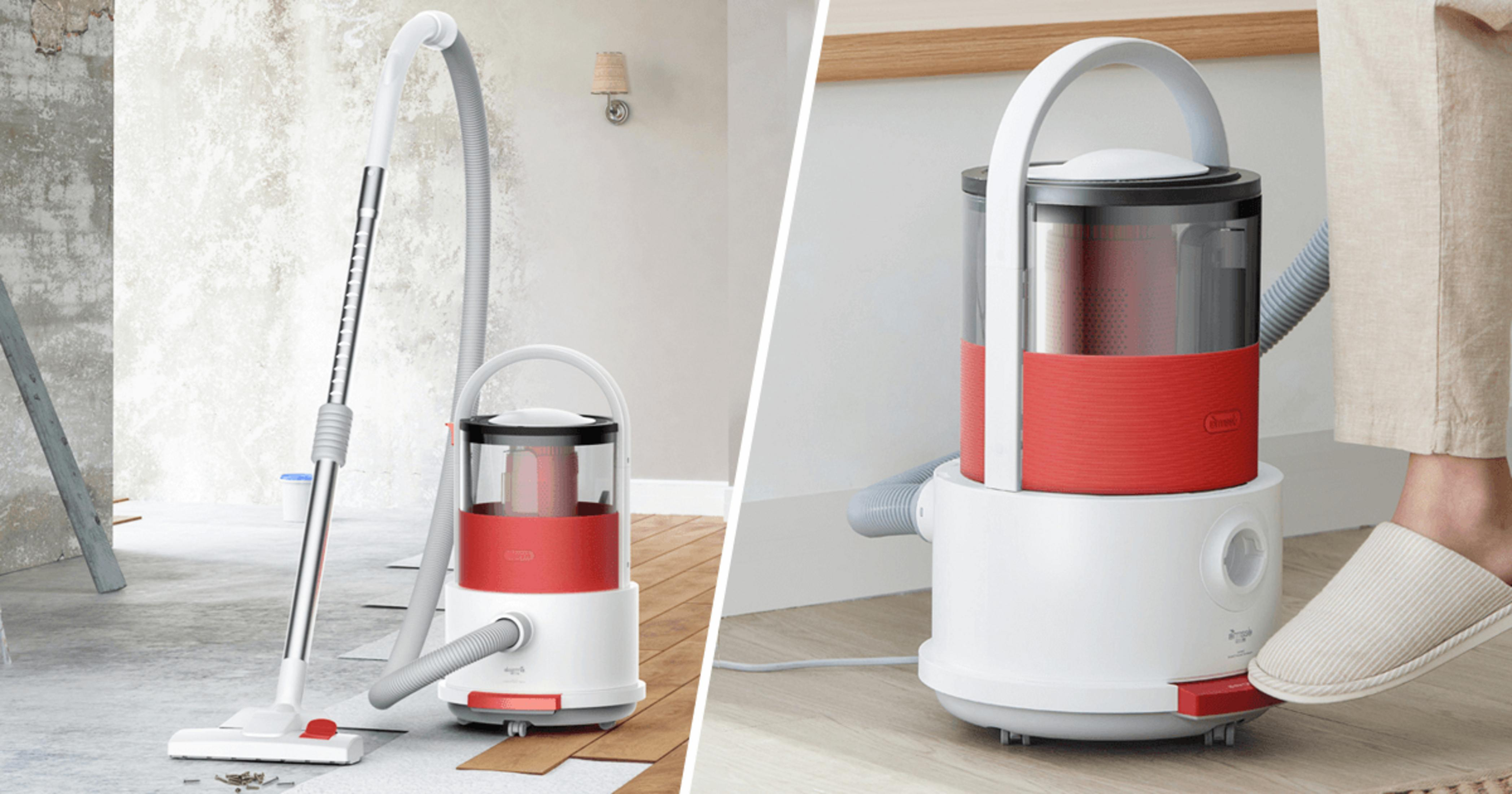 Aspirapolvere rosso e bianco con tubo lungo su pavimento in legno.