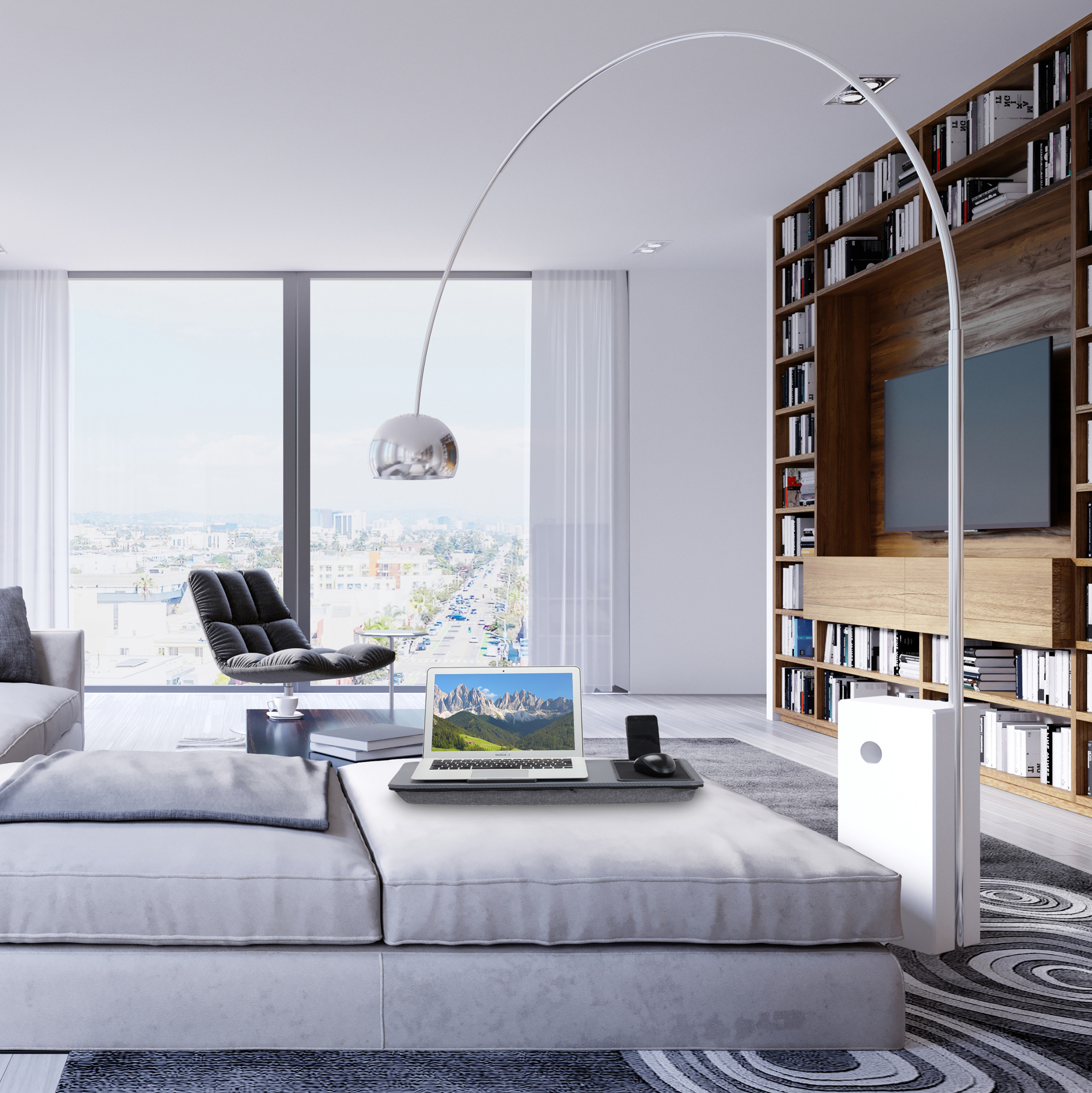 Moderne Wohnzimmer mit Laptop, grosser Bogenlampe, Buecherregal und Blick auf die Stadt durch ein Panoramafenster.
