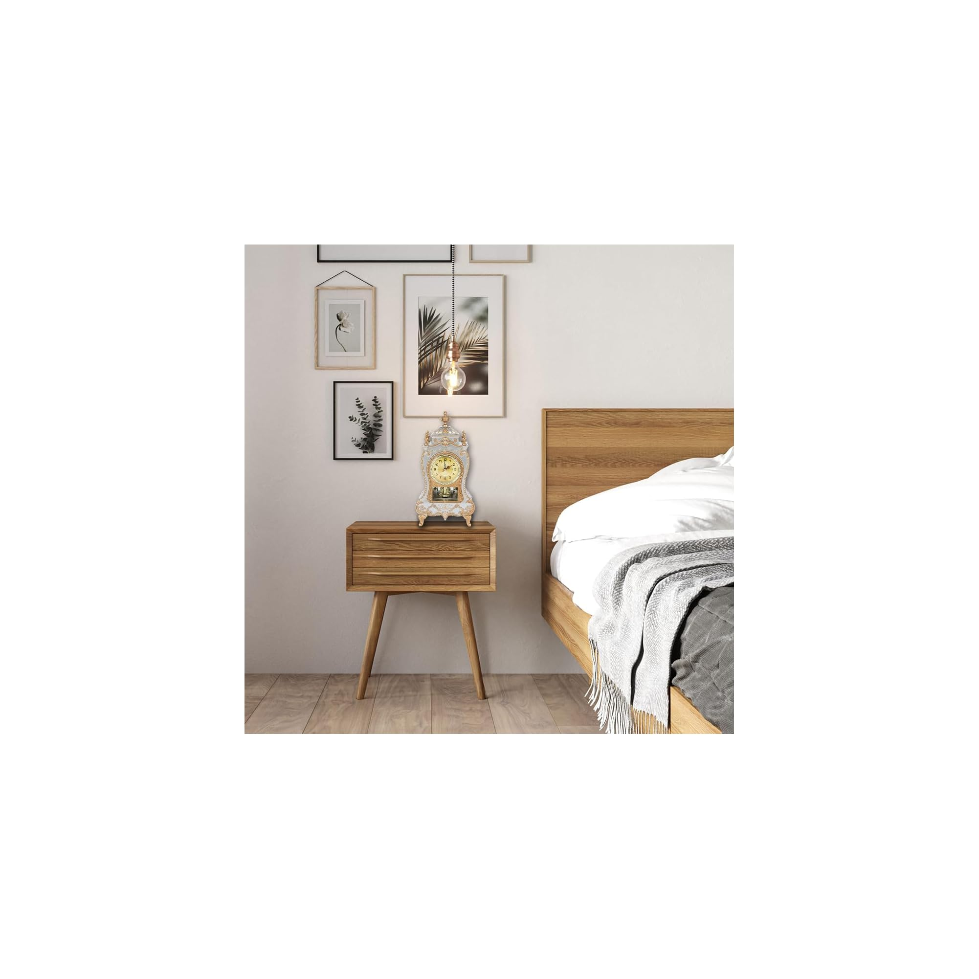 Eine Pendeluhr steht auf einem Nachttisch neben einem Bett, an der Wand hängen Bilder.