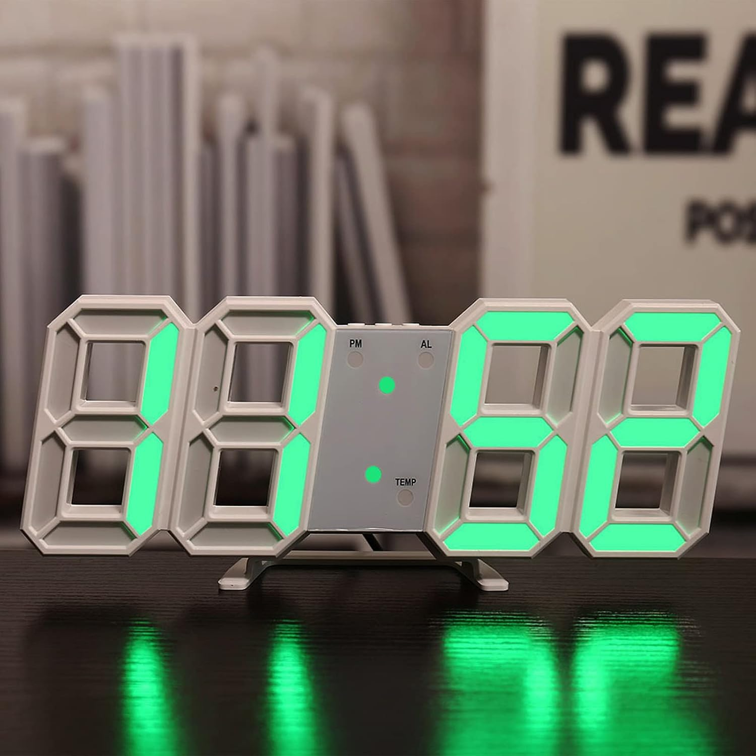 Eine weiße digitale LED-Uhr mit grünem Licht auf dunklem Tisch.