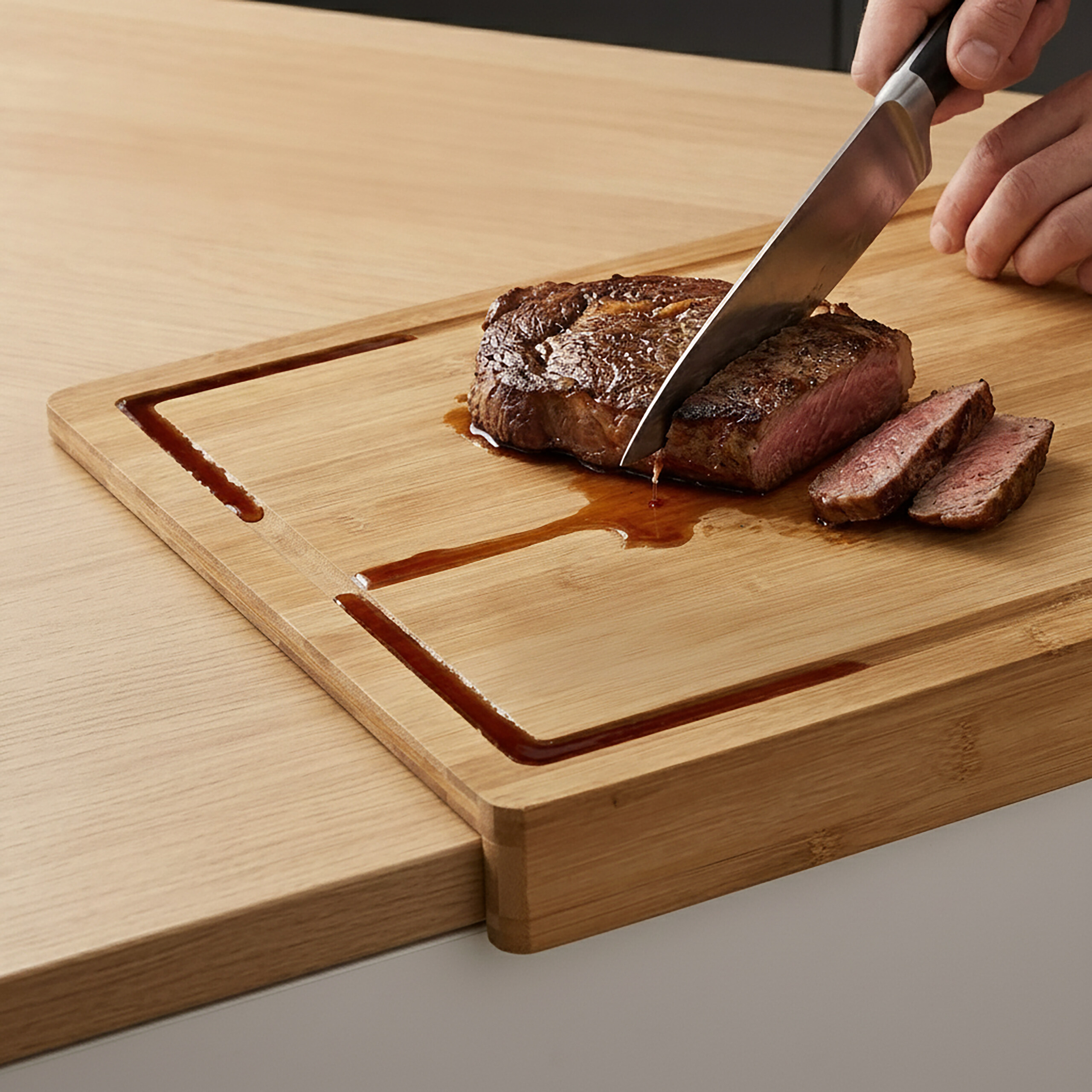 Una persona taglia una bistecca cotta su un tagliere di legno con un coltello, i succhi si accumulano nelle scanalature.