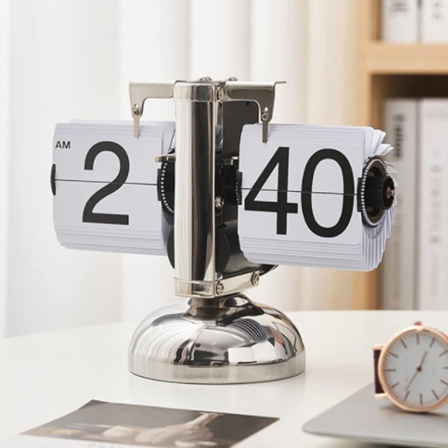 Eine silberne Retro-Klappzahlen-Uhr zeigt 2:40 Uhr auf einem weißen Tisch.